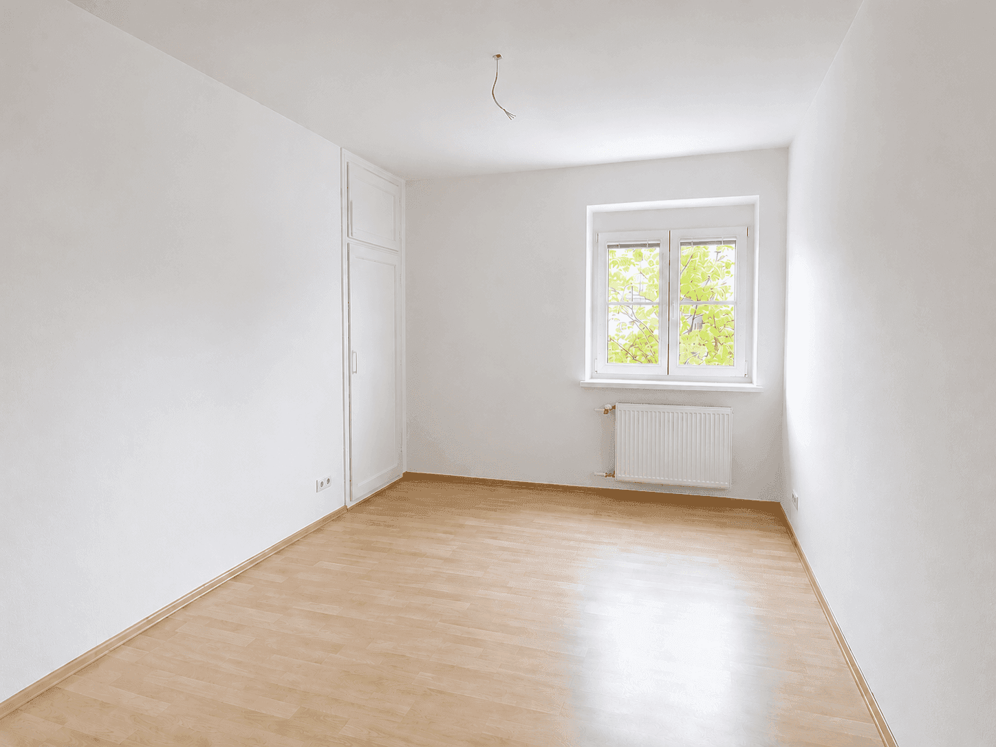 Zimmer mit Laminatboden und integriertem Wandschrank, bietet praktischen Stauraum.