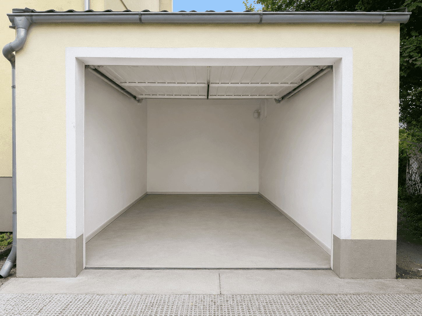 Leere Einzelgarage mit Rolltor, bietet sicheren Stellplatz für ein Fahrzeug.