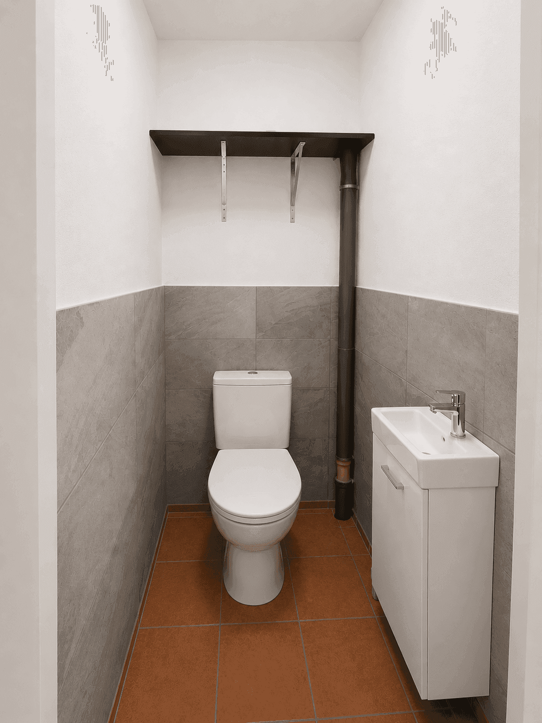 Praktisches Gäste-WC mit WC, Waschbecken und halbhohen Fliesen in Grau.