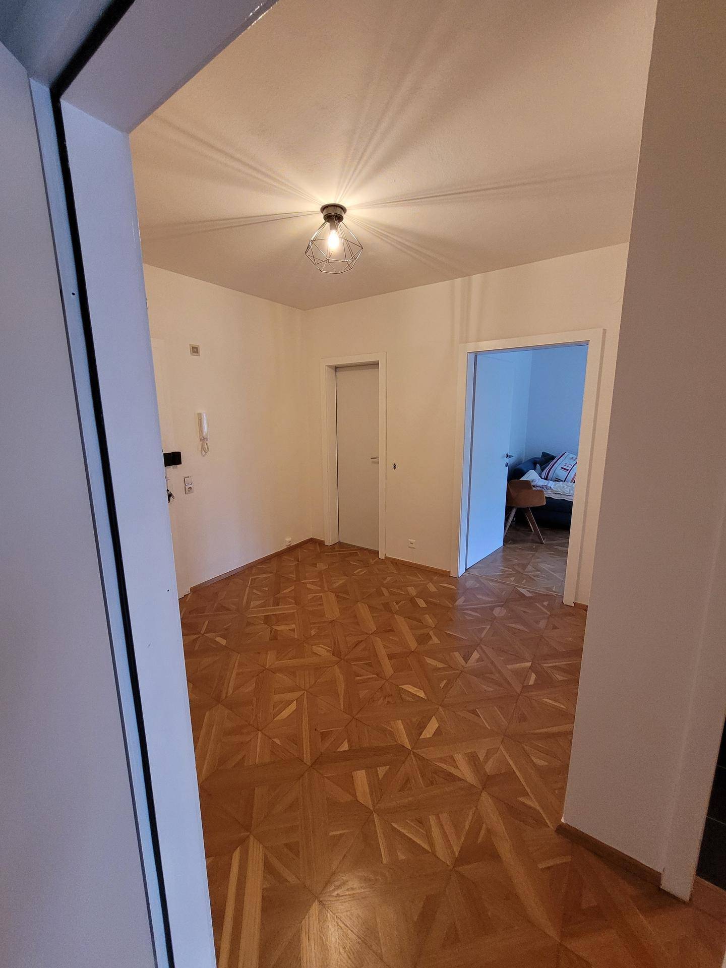 Heller Flur mit Parkettboden, der zu verschiedenen Räumen der Wohnung führt.