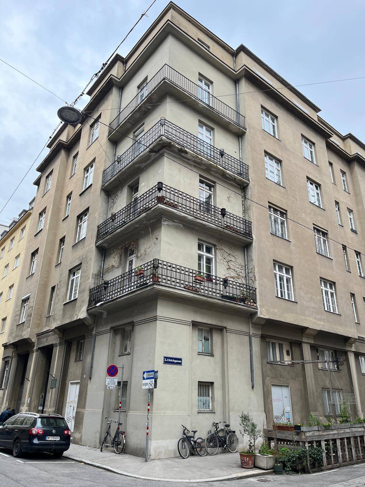 Detailansicht des Eckgebäudes mit geschwungenen Balkonen und urbanem Flair.