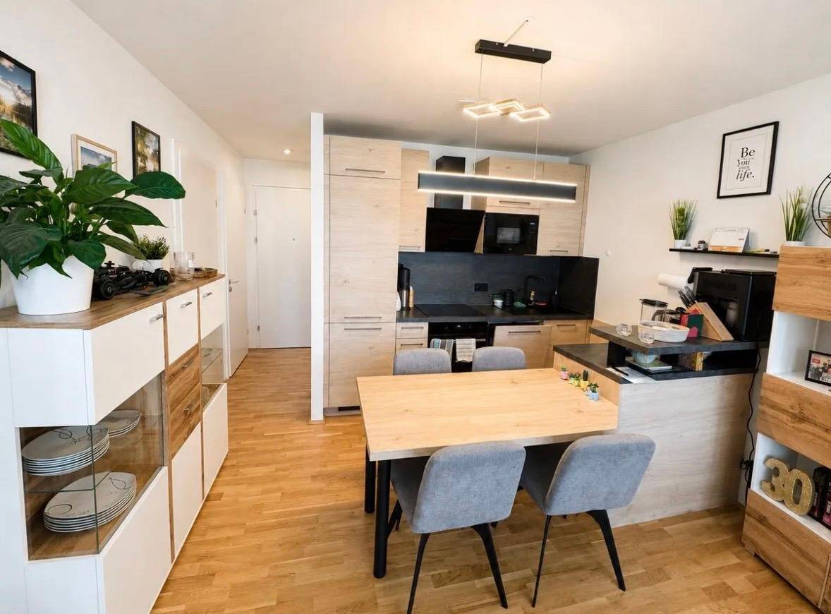 Moderne offene Küche mit Holzelementen und Essbereich, ideal für geselliges Beisammensein.