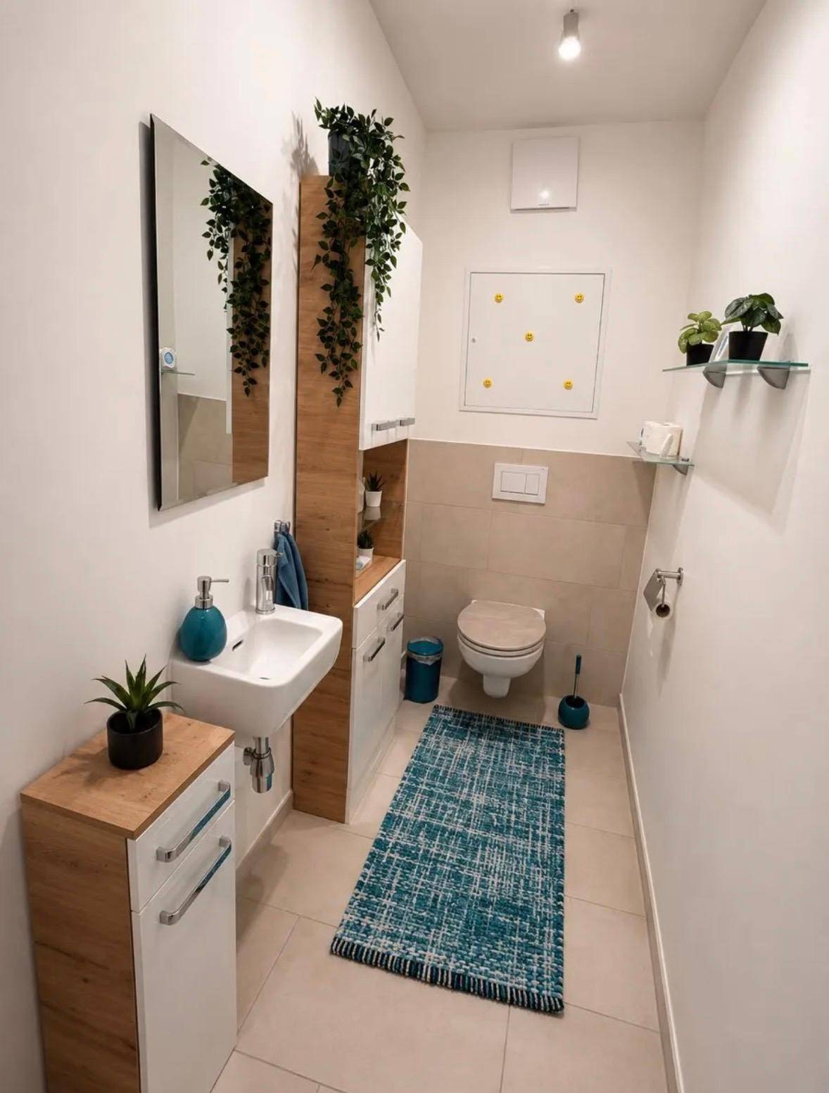 Modernes Gäste-WC mit Wand-WC und kleinem Waschbecken, hell gefliest.