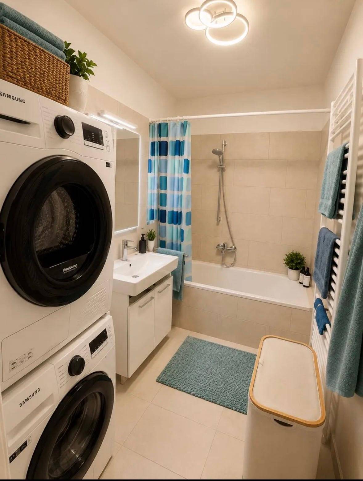 Funktionales Badezimmer mit Badewanne, Dusche und integrierter Waschmaschine.