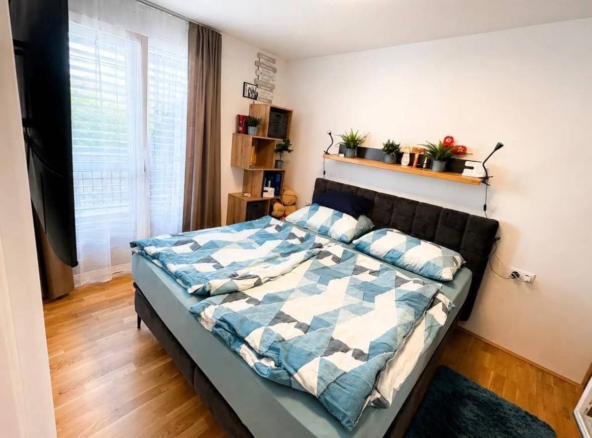 Gemütliches Schlafzimmer mit Doppelbett, Holzboden und Zugang zu einem Balkon.