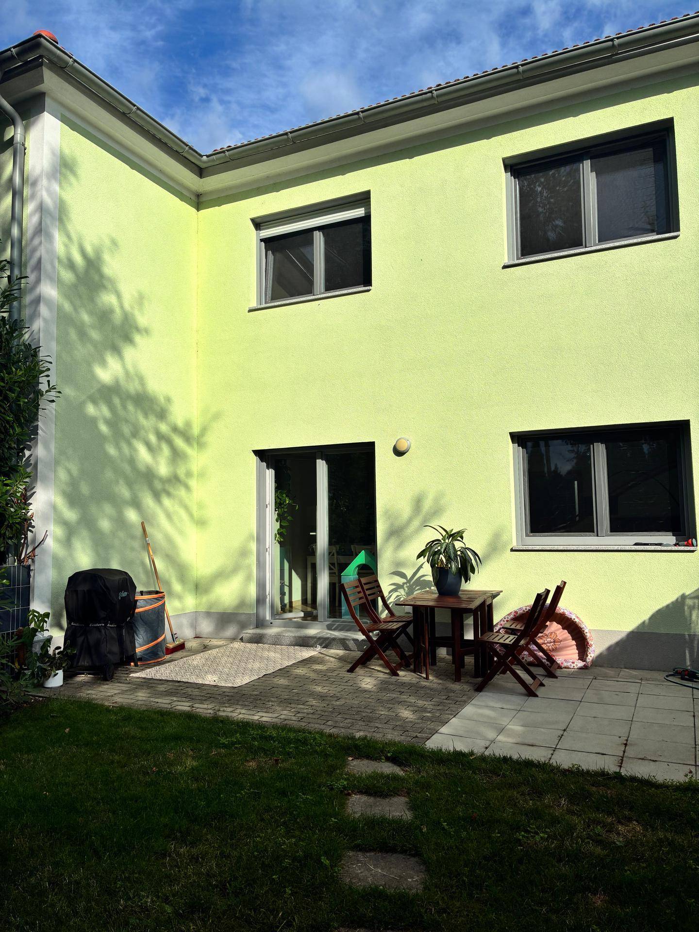 Terrasse mit Gartenmöbeln und Zugang zum Garten, ideal für Entspannung im Freien.