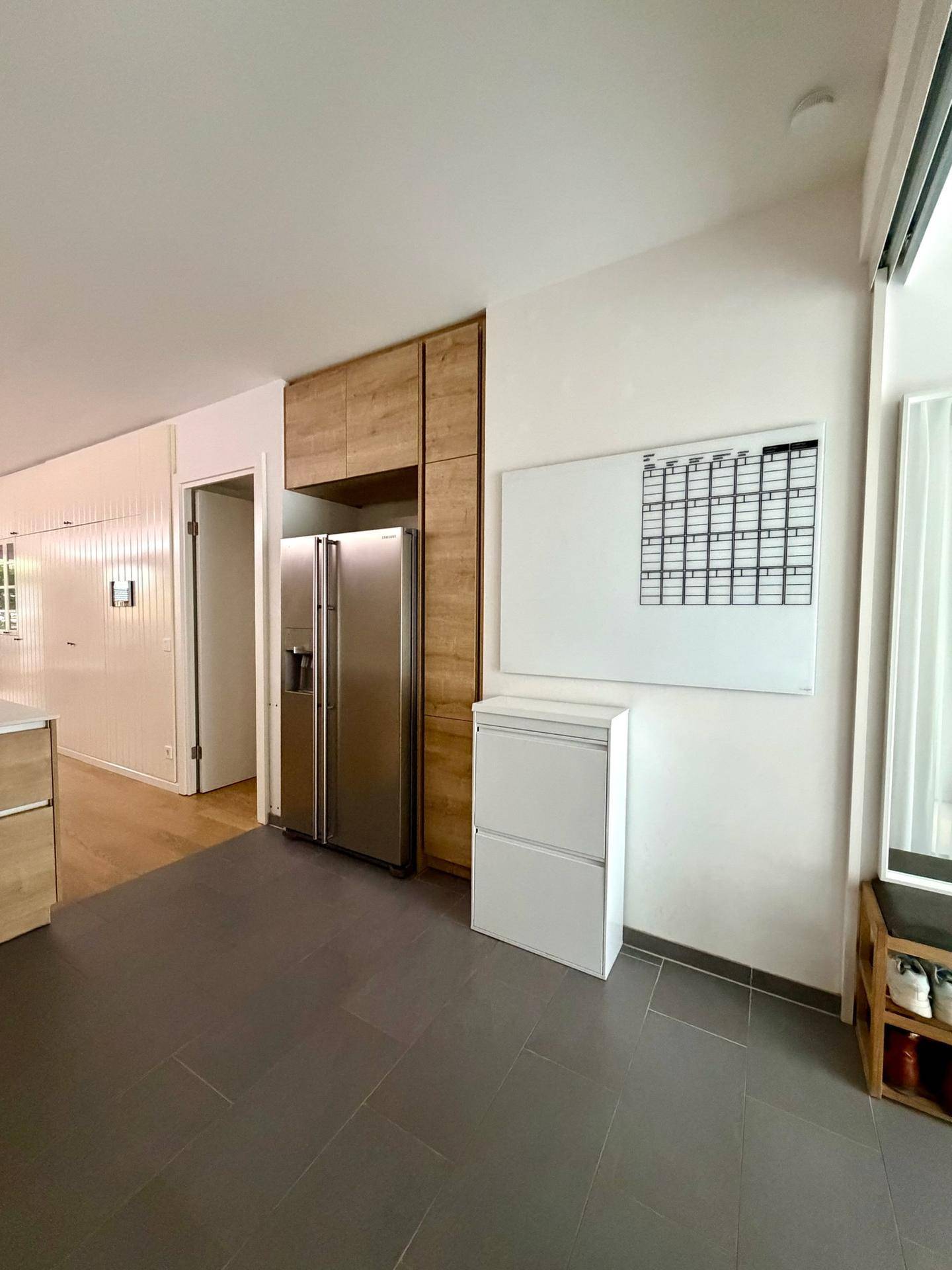 Küchenbereich mit großem Edelstahlkühlschrank und praktischer Wandtafel für Notizen.