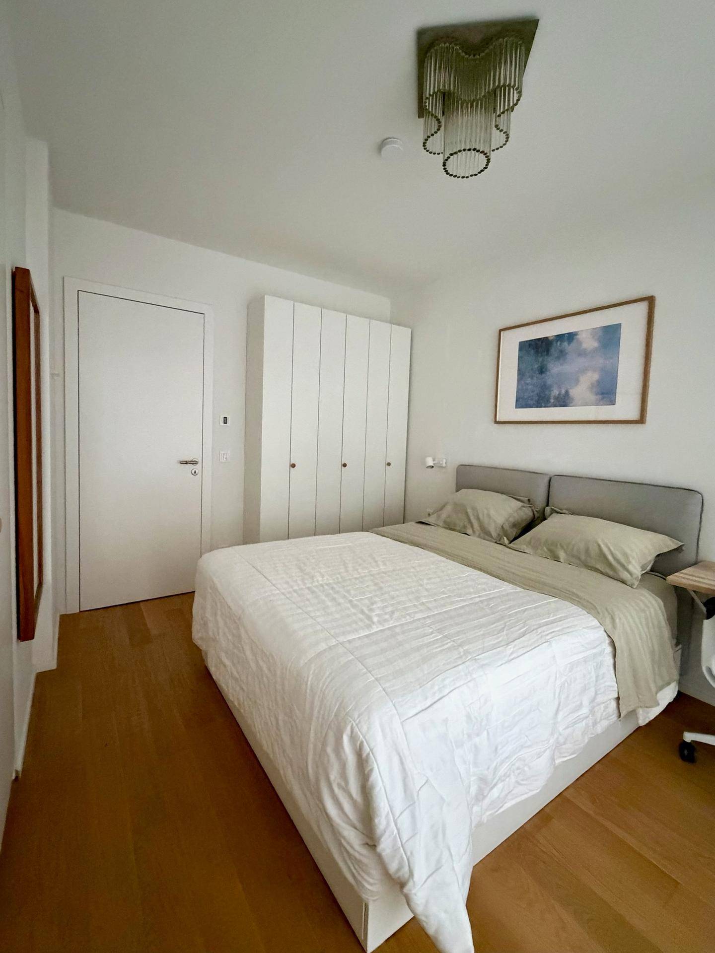 Schlafzimmer mit Doppelbett und praktischen weißen Einbauschränken.