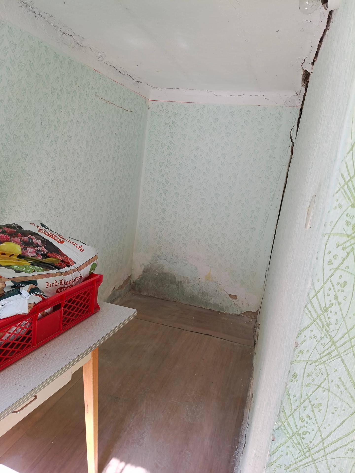 Kleiner Abstellraum mit gemusterter Tapete und begrenztem Platz.