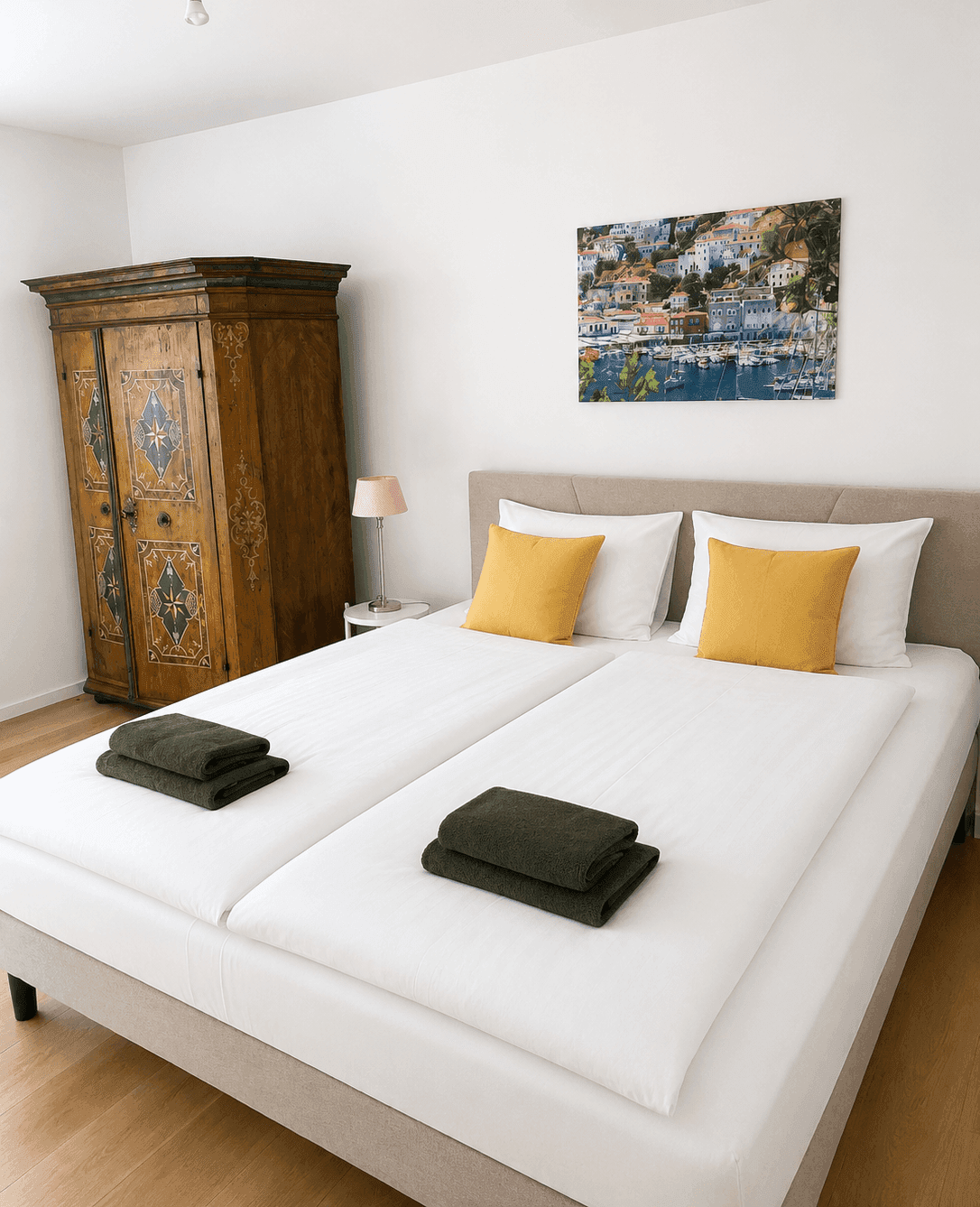 Gemütliches Schlafzimmer mit Doppelbett, Holzkleiderschrank und gelben Akzenten.