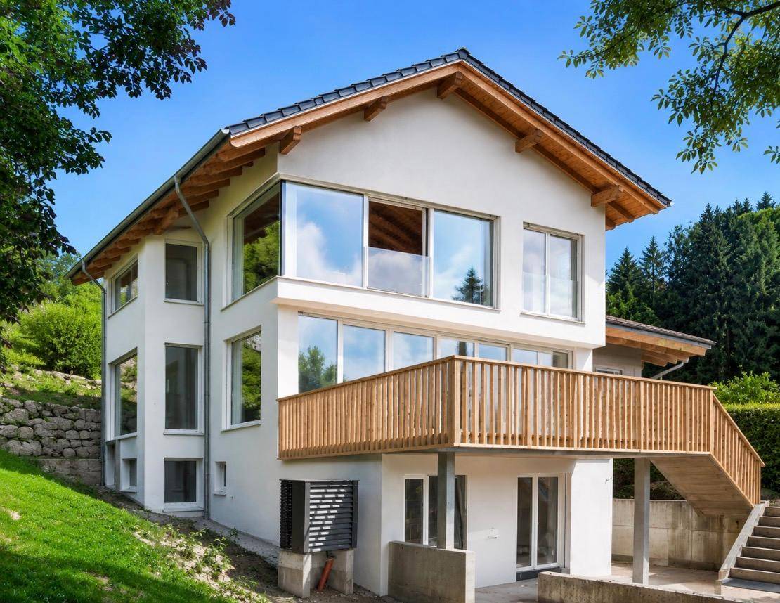 Modernes Wohnhaus mit weißer Fassade, großen Fenstern und Holzgeländer.