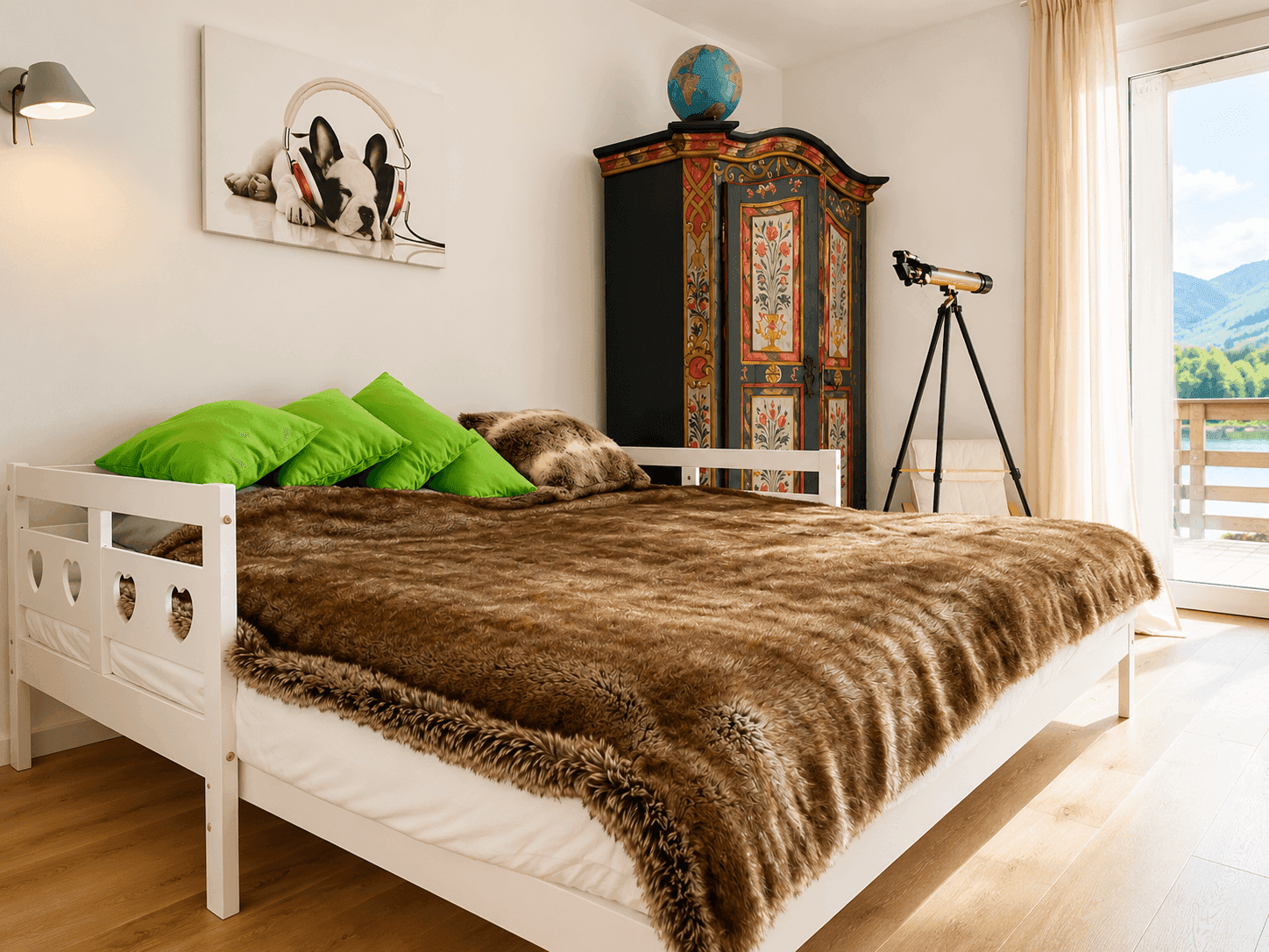 Schlafzimmer mit Tagesbett, farbenfrohem Schrank und Zugang zum Balkon mit Seeblick.