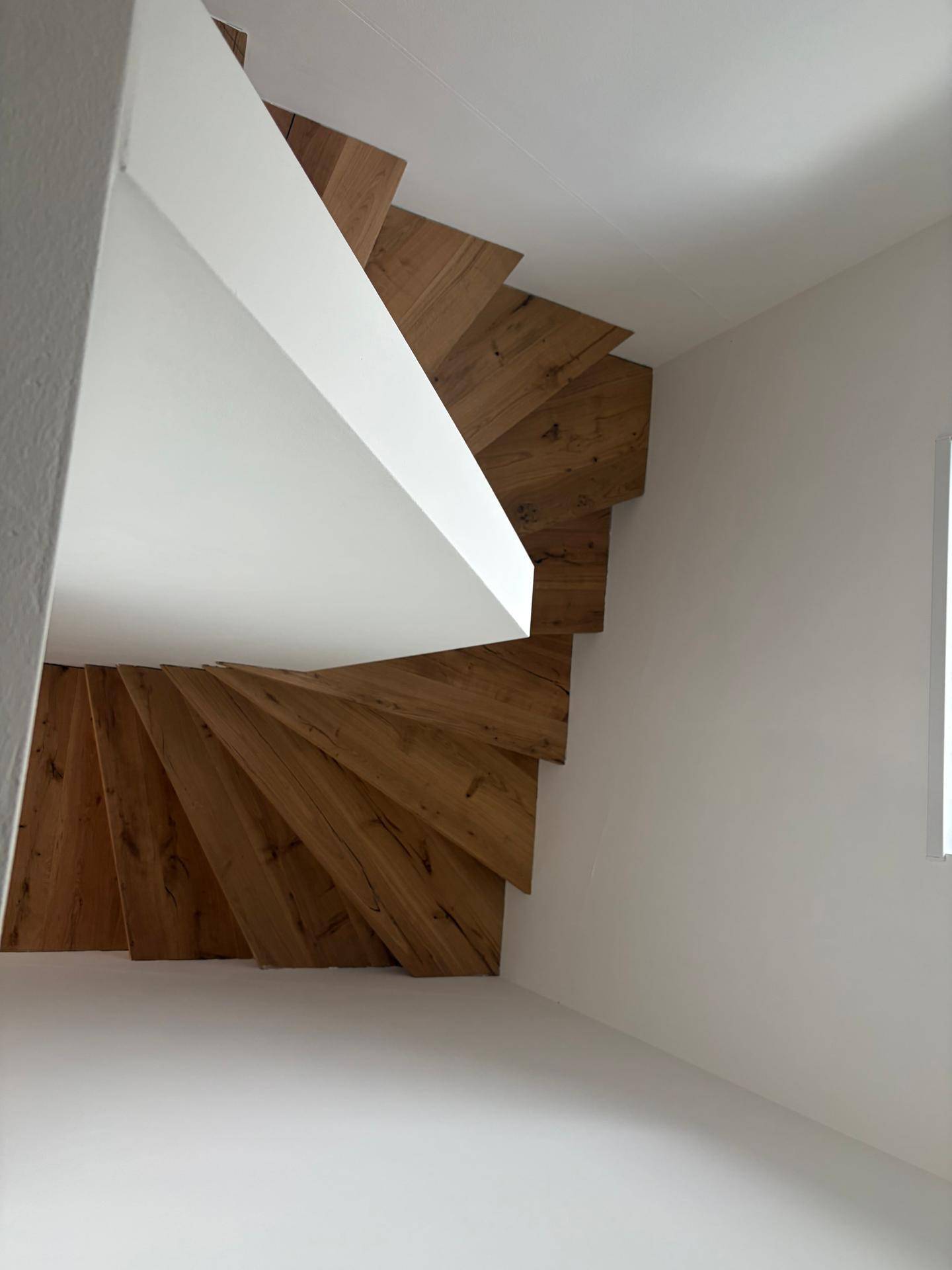 Elegante Holztreppe mit minimalistischem Design und viel Tageslicht.