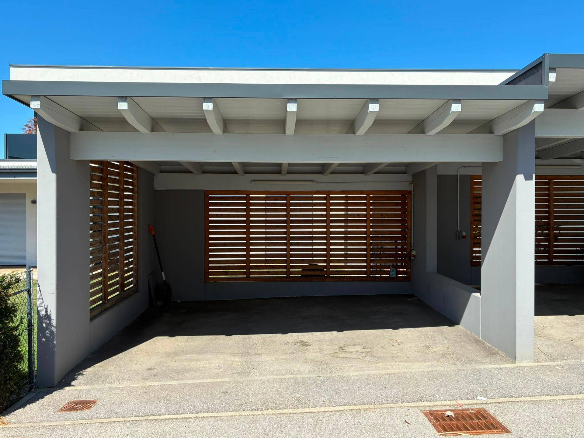 Moderner Carport mit Holzlamellen und zwei Stellplätzen.
