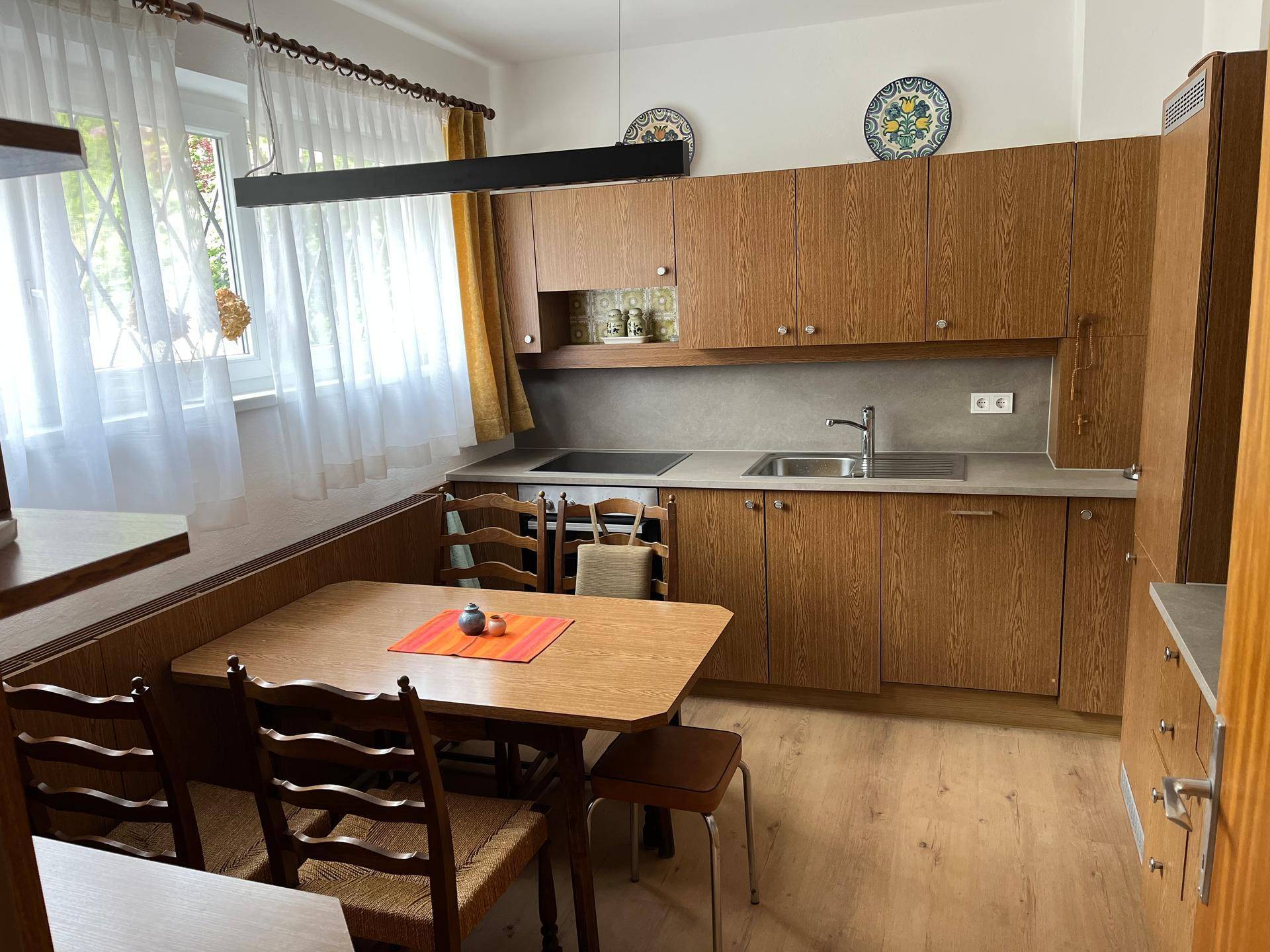 Gemütliche Wohnküche im traditionellen Stil mit Holzelementen, Essbereich und Fenster für Tageslicht.