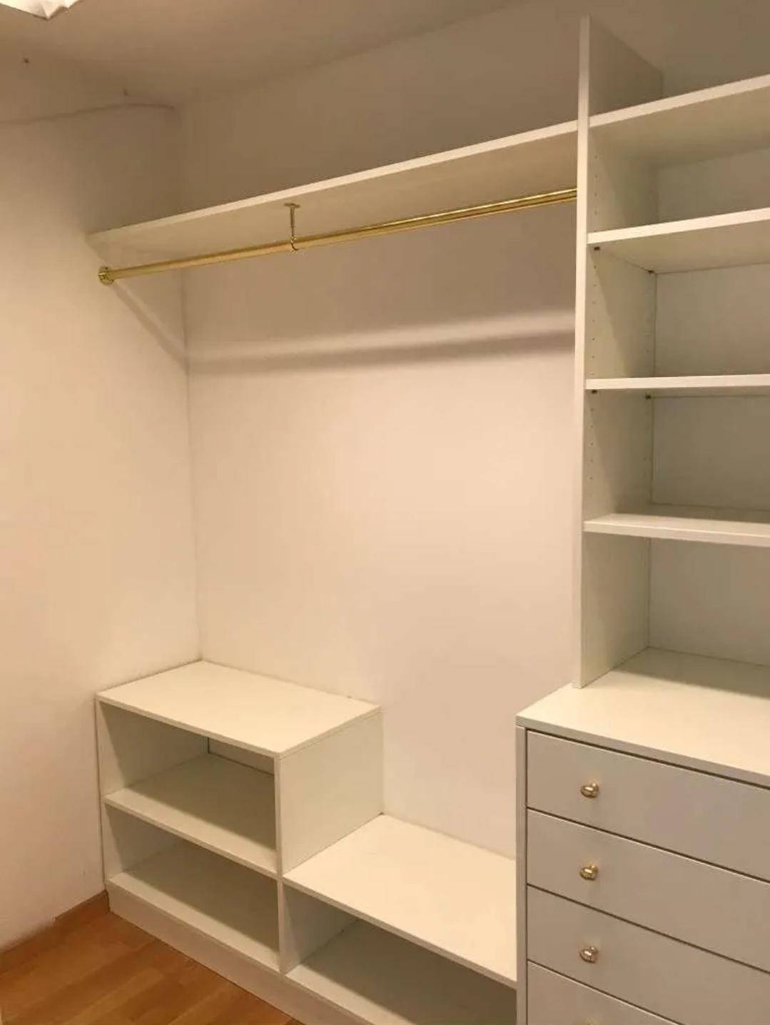 Geräumiger begehbarer Kleiderschrank mit Regalen, Schubladen und Kleiderstange für optimale Organisation.