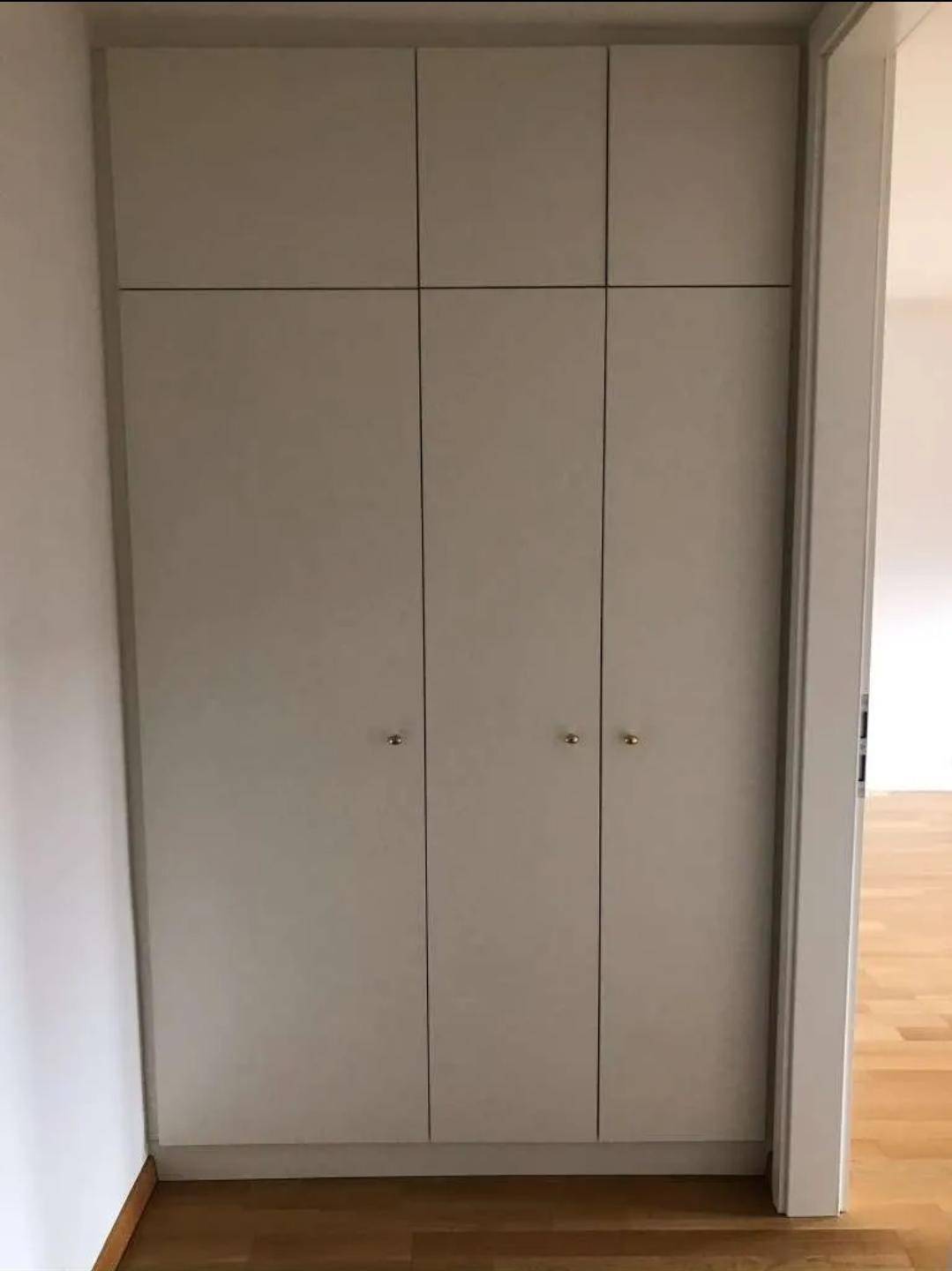 Praktischer Einbauschrank mit hellgrauen Türen, der sich nahtlos in die Wand integriert.