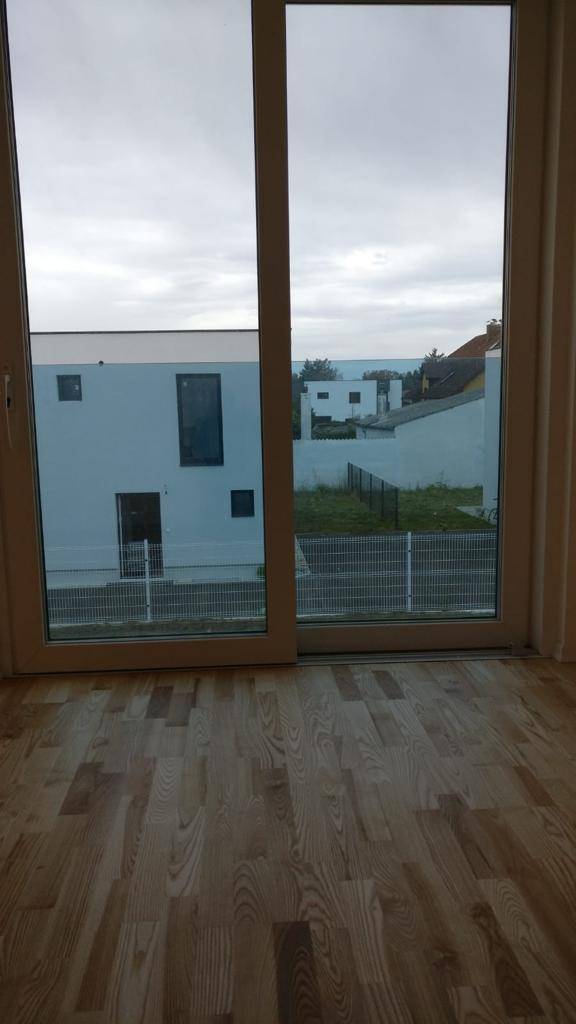 Blick aus dem Fenster eines Zimmers auf die Nachbarhäuser und den weiten Horizont.