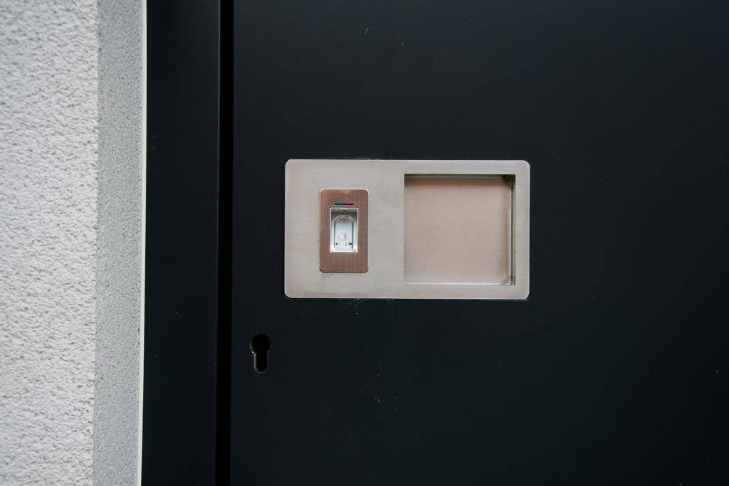 Detailansicht des modernen Türgriffs mit integriertem Fingerabdruckscanner für schlüssellosen Zugang.