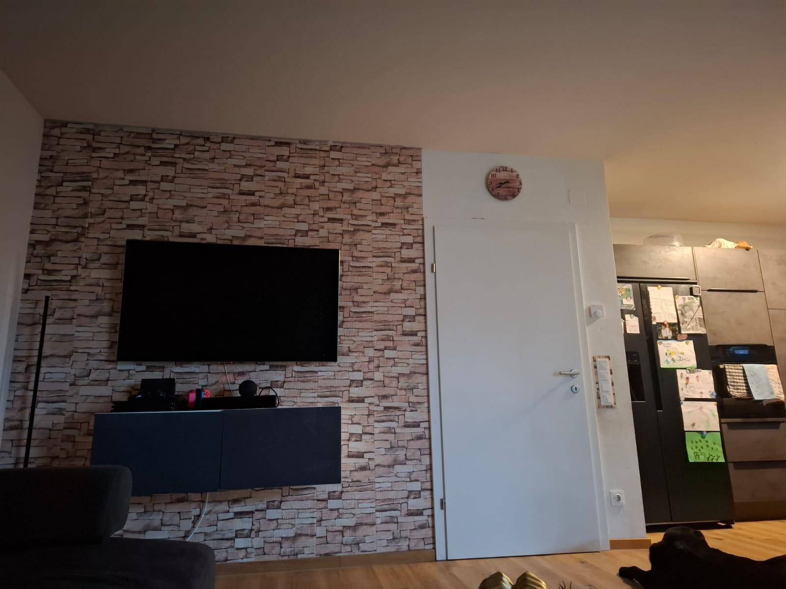 Wohnzimmerwand mit montiertem Fernseher, schwebendem Sideboard und dekorativer Ziegelstein-Tapete.