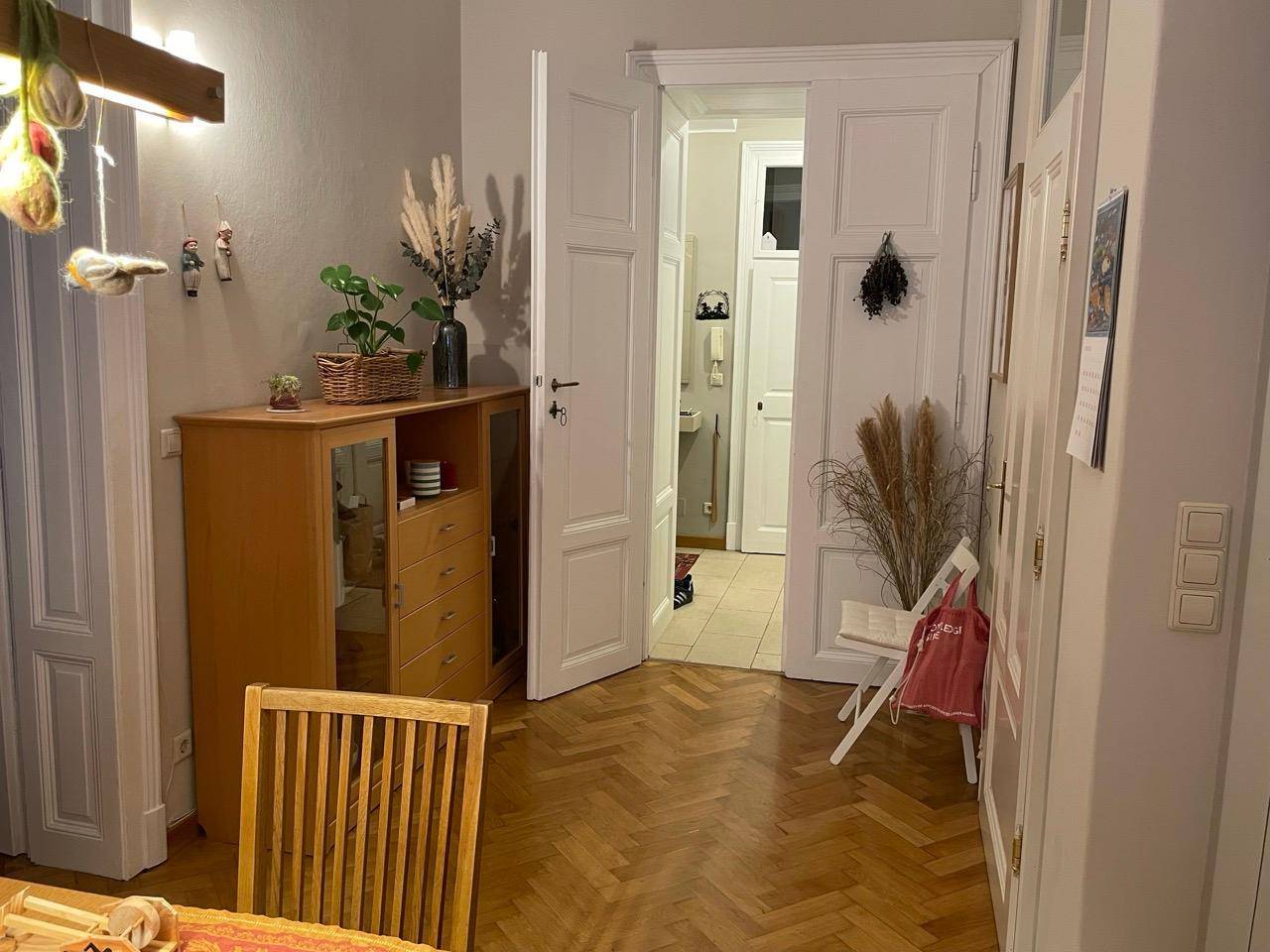 Heller Flur mit Parkettboden und Zugang zu weiteren Räumen, ausgestattet mit einem Sideboard.