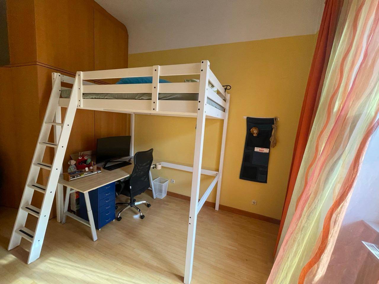 Kinderzimmer mit Hochbett, integriertem Schreibtisch und viel Tageslicht.