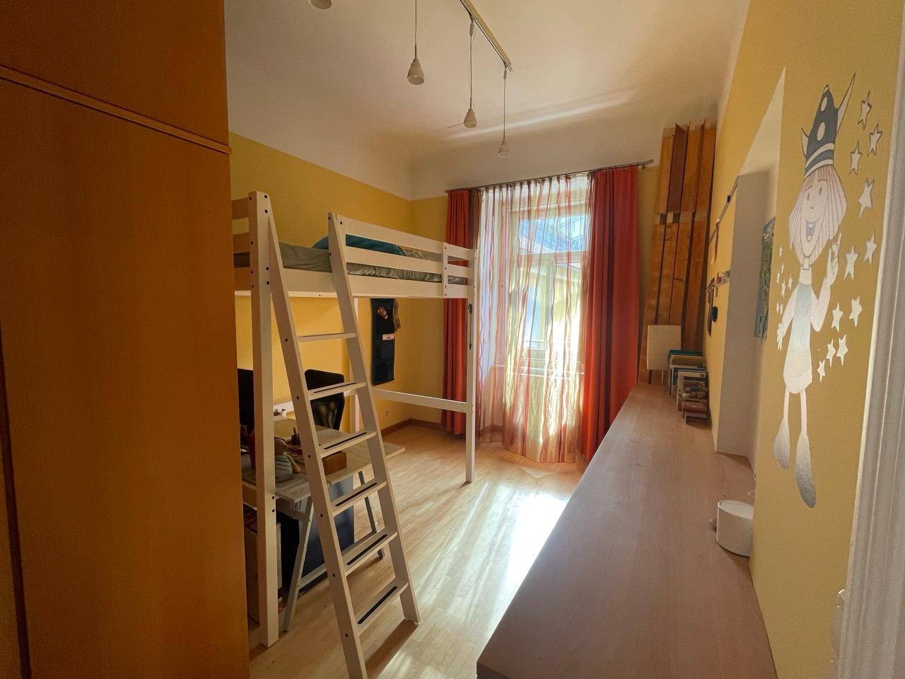 Kinderzimmer mit Hochbett, Schreibtisch und bunten Wänden, hell und freundlich gestaltet.