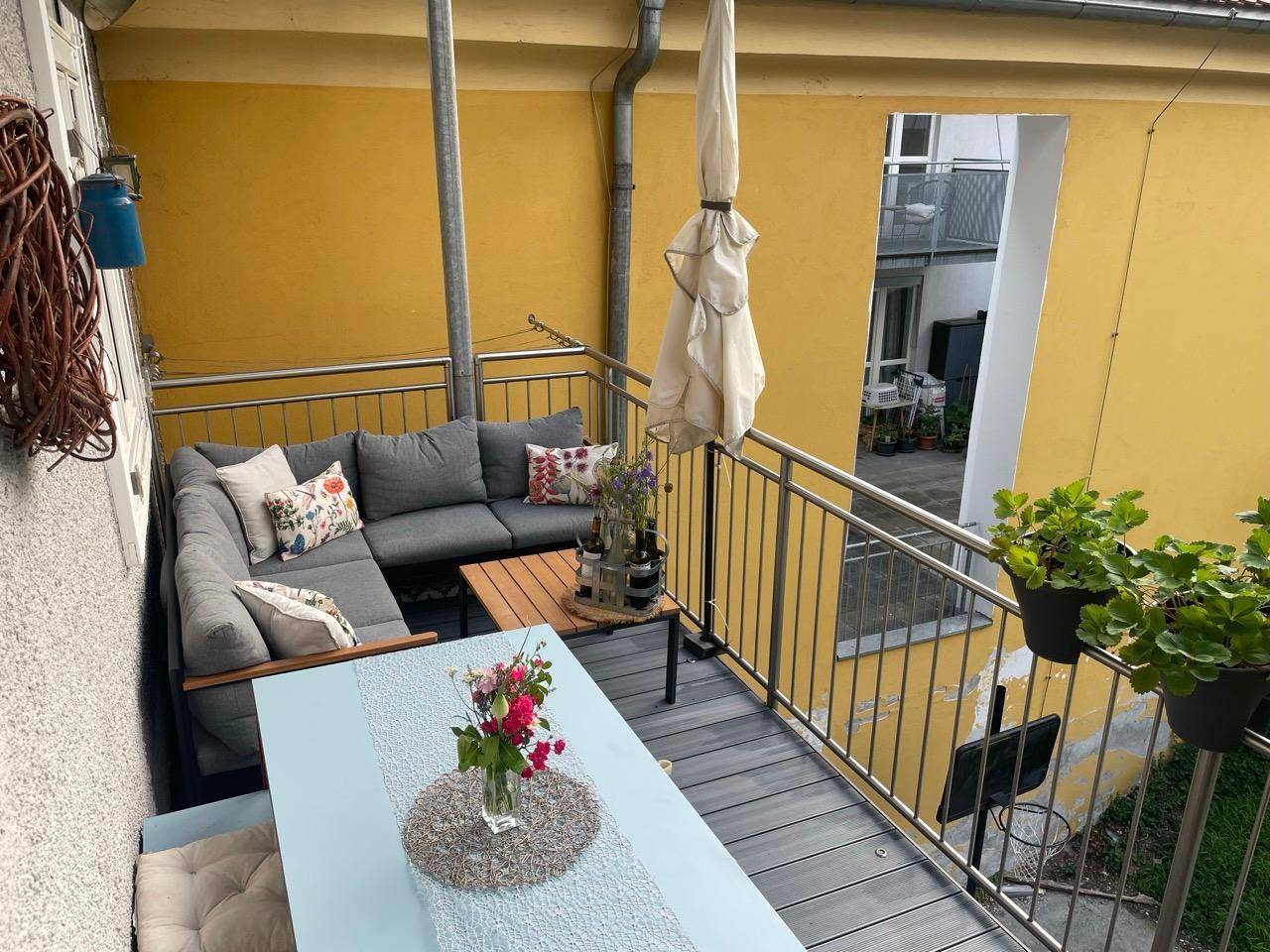 Heller Balkon mit Lounge-Möbeln und Esstisch, bietet Platz für Erholung im Freien.