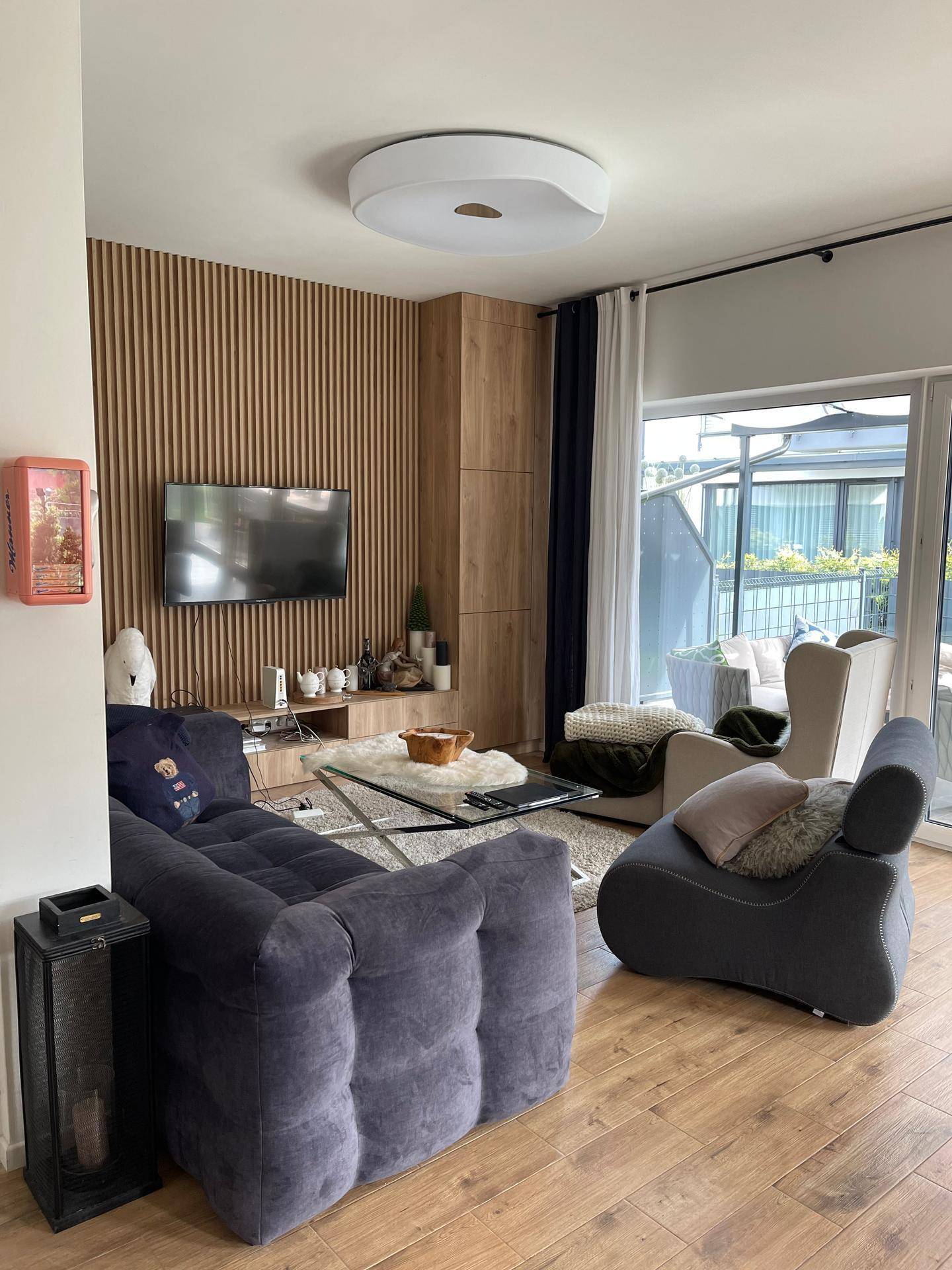 Gemütliches Wohnzimmer mit großem Sofa, Holzboden und Zugang zur Terrasse.