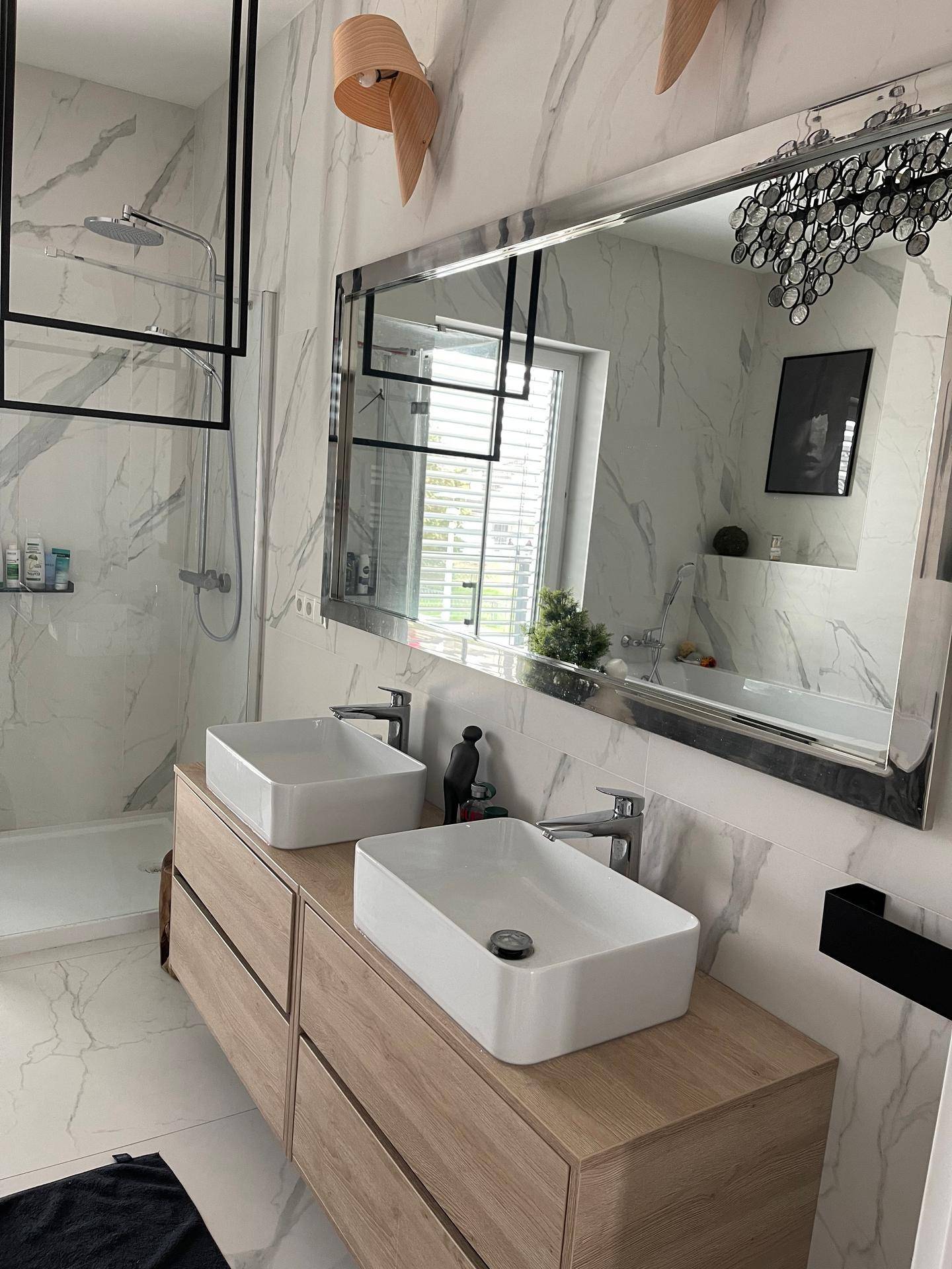 Modernes Badezimmer mit Doppelwaschbecken, Marmorfliesen und großem Spiegel.