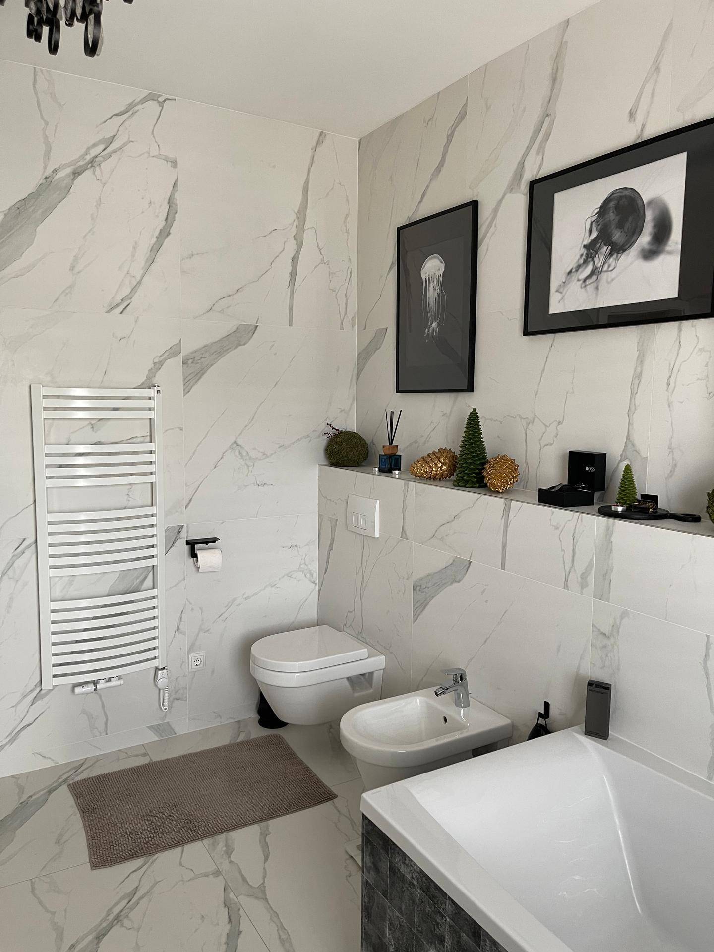 Elegantes Badezimmer mit Bidet, Wand-WC, beheiztem Handtuchhalter und Marmorfliesen.