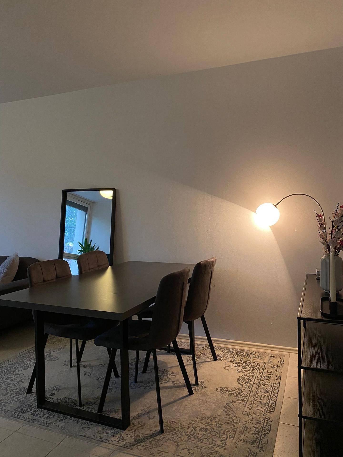 Moderner Essbereich mit dunklem Holztisch und eleganten Stühlen.