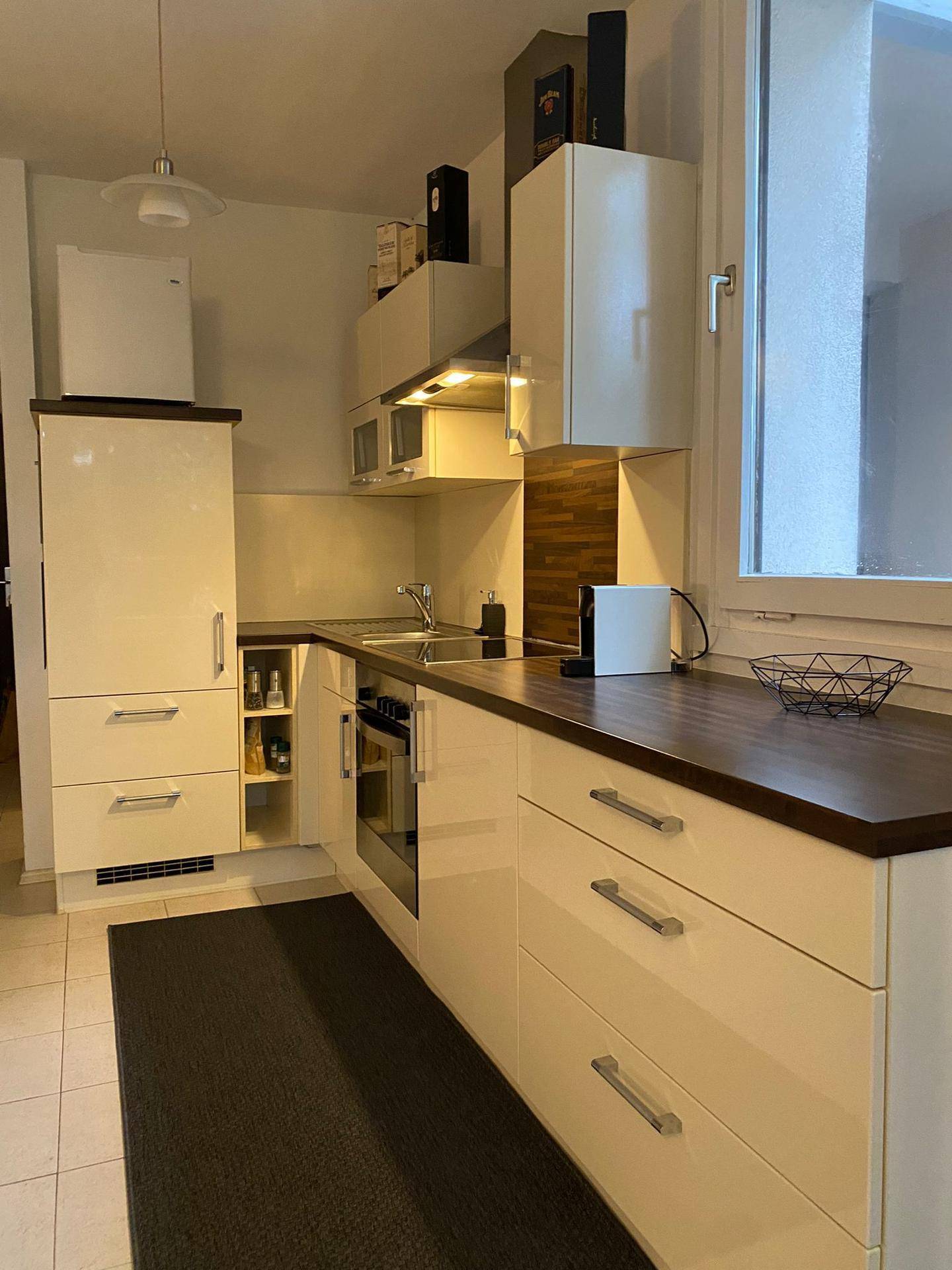 Moderne Küche mit integrierten Geräten, viel Stauraum und Holzdetails.