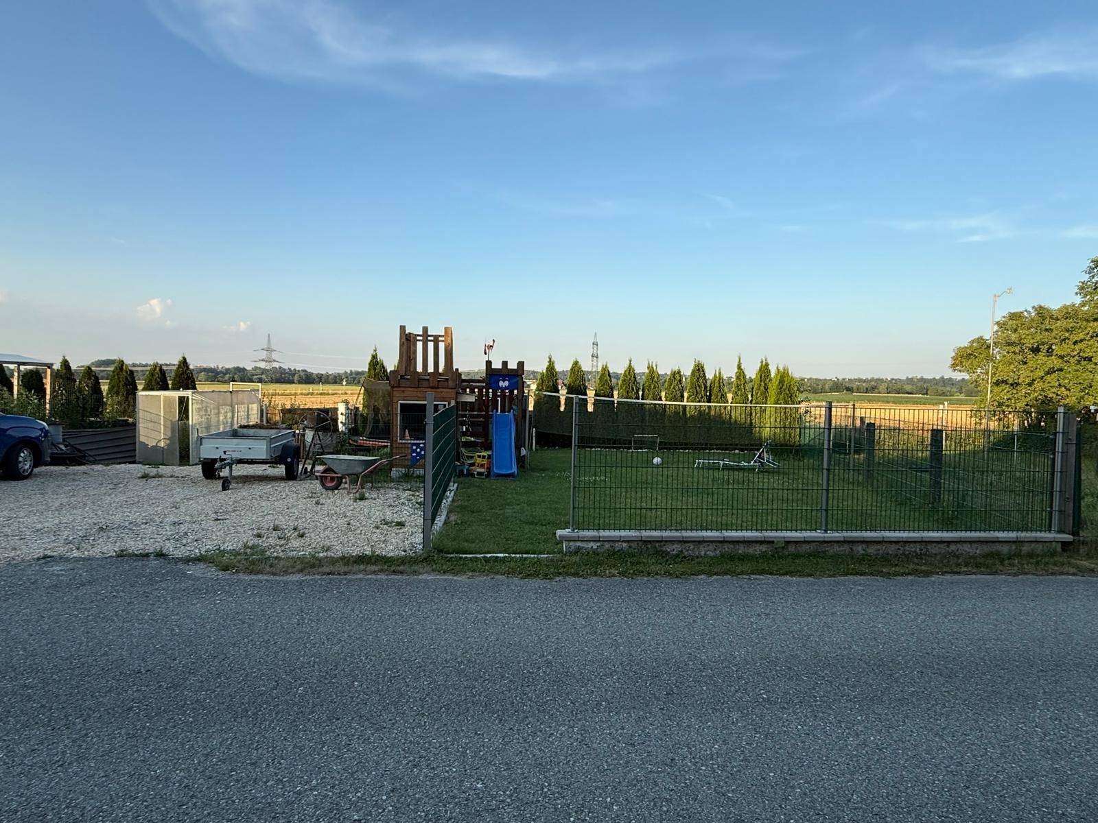 Großer Garten mit Spielplatz, Rasenfläche und Blick auf die umliegende Landschaft.
