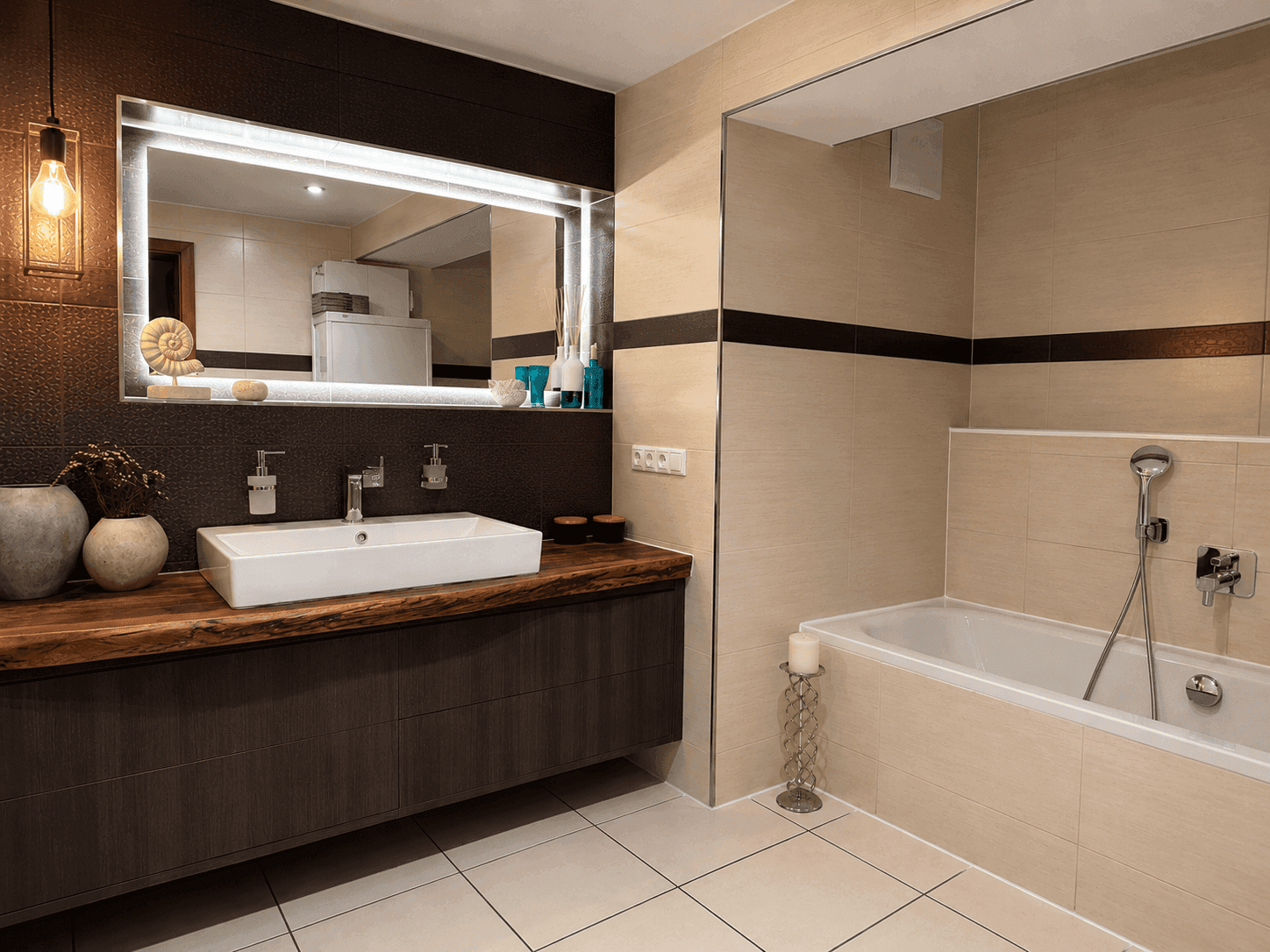 Geräumiges Badezimmer mit Badewanne, großem Waschtisch und beleuchtetem Spiegel.