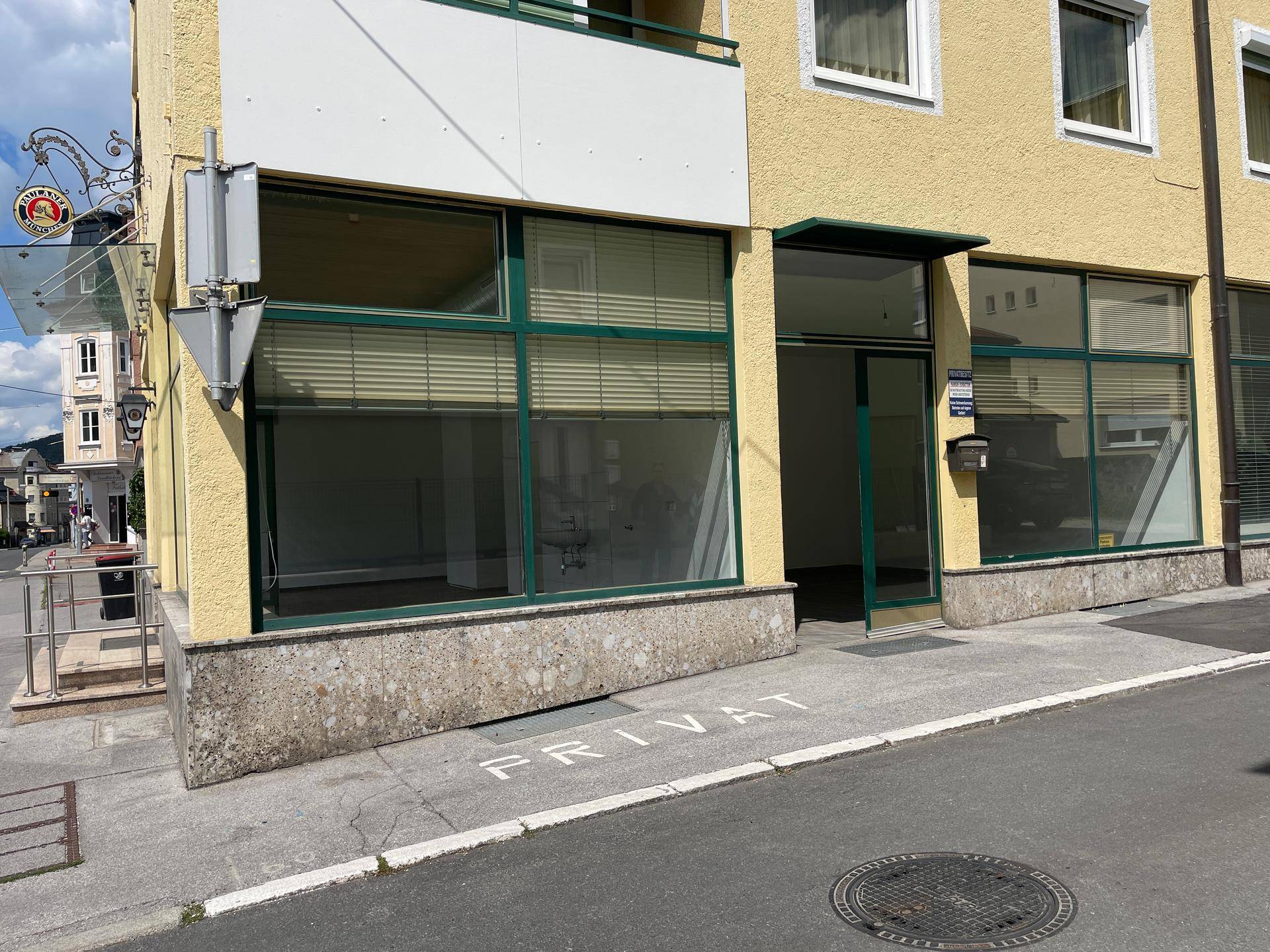 Ecke des Geschäftsgebäudes mit großen Schaufenstern und einem 