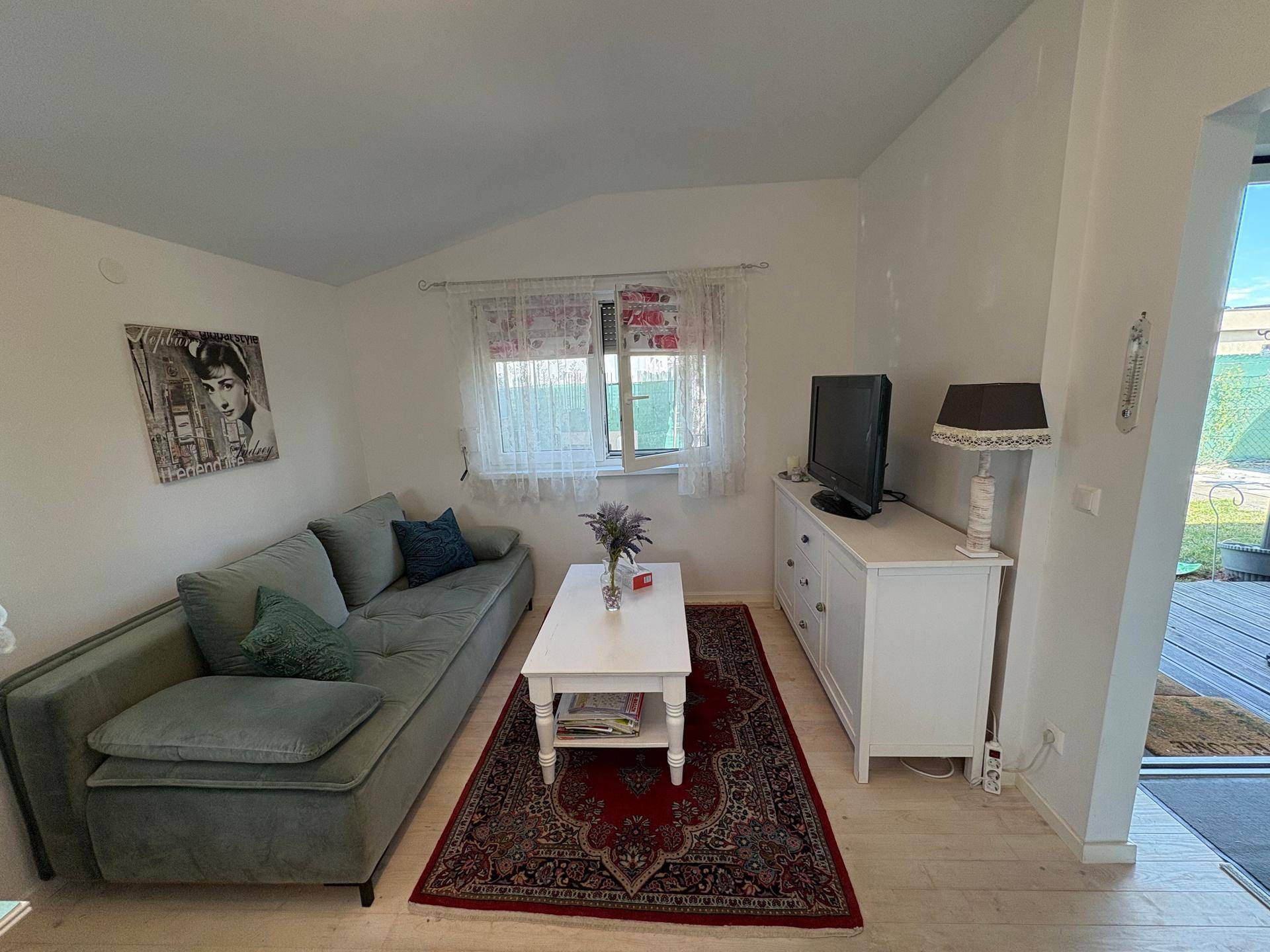 Gemütliches Wohnzimmer mit Sofa, Couchtisch und Teppich auf hellem Holzboden.