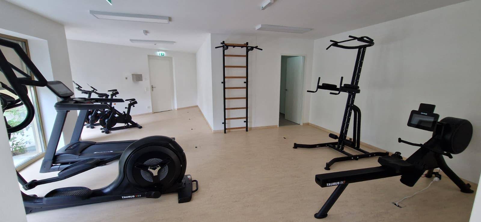 Gut ausgestatteter Fitnessraum mit verschiedenen Trainingsgeräten für die Bewohner.