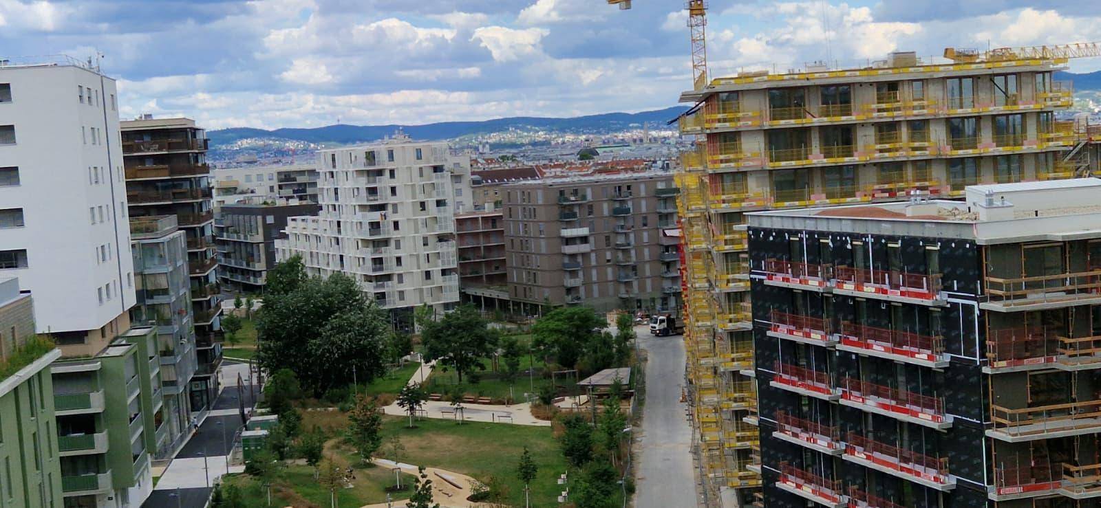 Panoramablick auf eine moderne Stadtlandschaft mit neuen Wohngebäuden und Grünflächen.