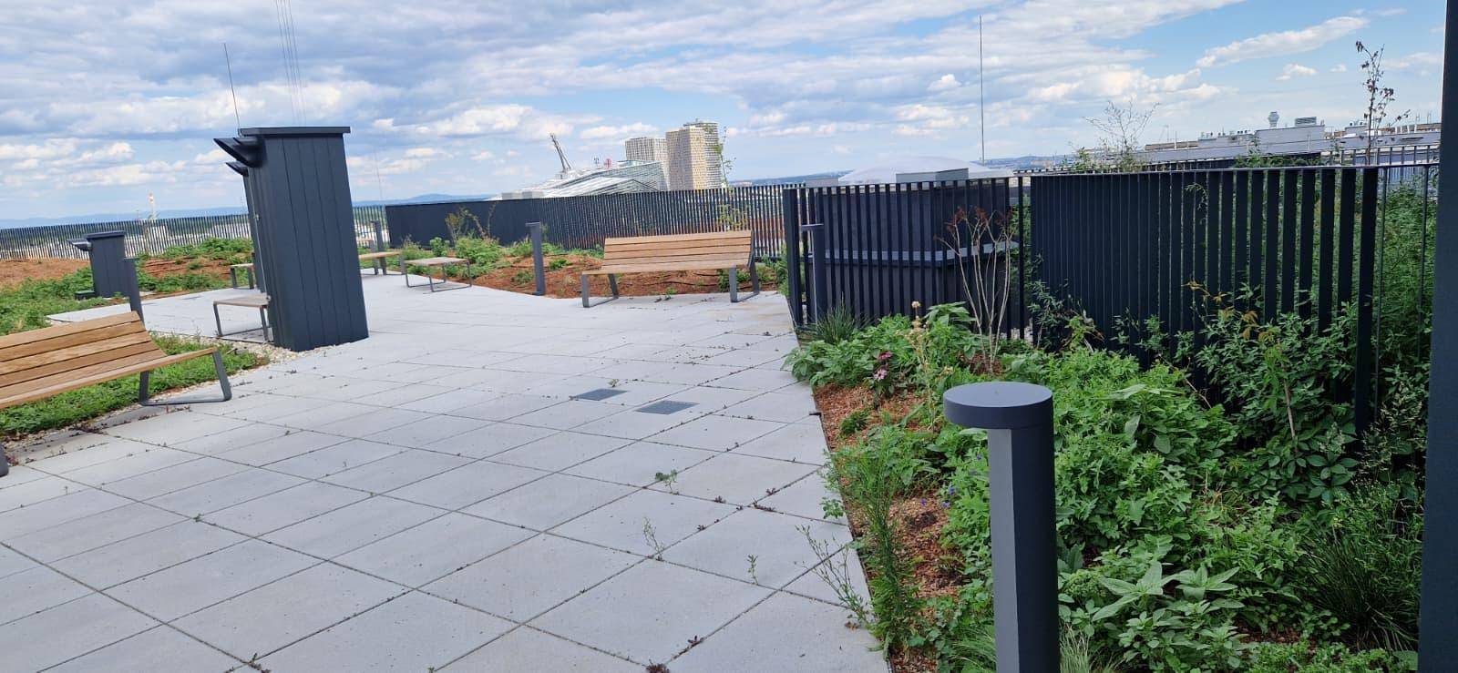 Gemeinschaftliche Dachterrasse mit Sitzgelegenheiten und Bepflanzung, ideal zum Entspannen.