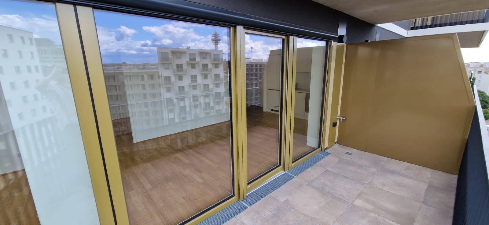 Geräumiger Balkon mit Fliesenboden und Blick auf die umliegenden Gebäude.