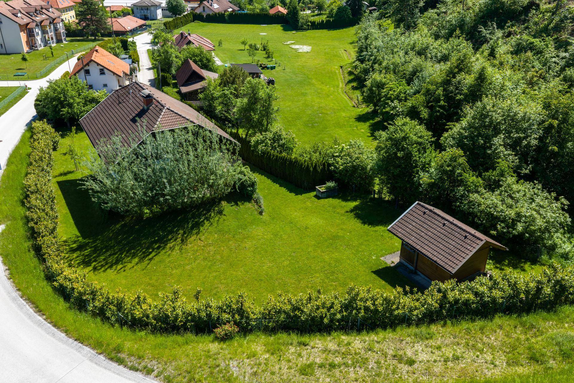 Luftaufnahme des Einfamilienhauses mit großem Grundstück, Gartenhaus und umliegender grüner Landschaft.