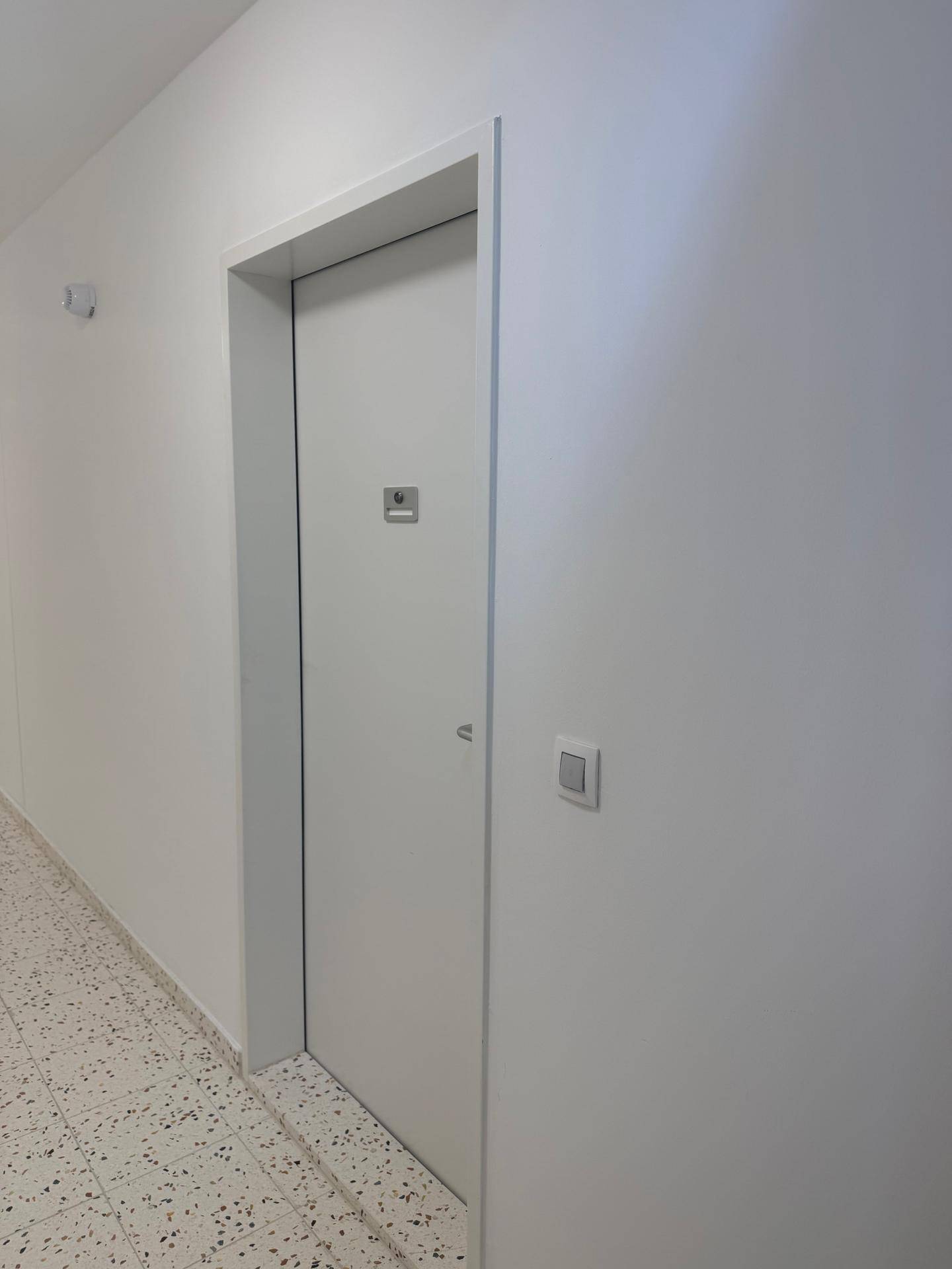 Eingangstür einer Wohnung in einem hellen, gefliesten Flur.