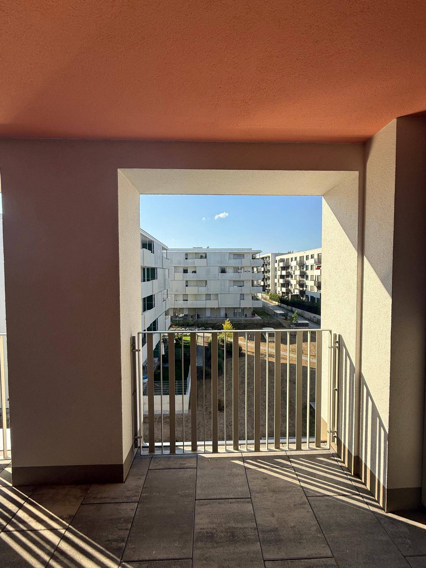 Überdachte Terrasse mit Ausblick auf den Innenhof und die Grünflächen.