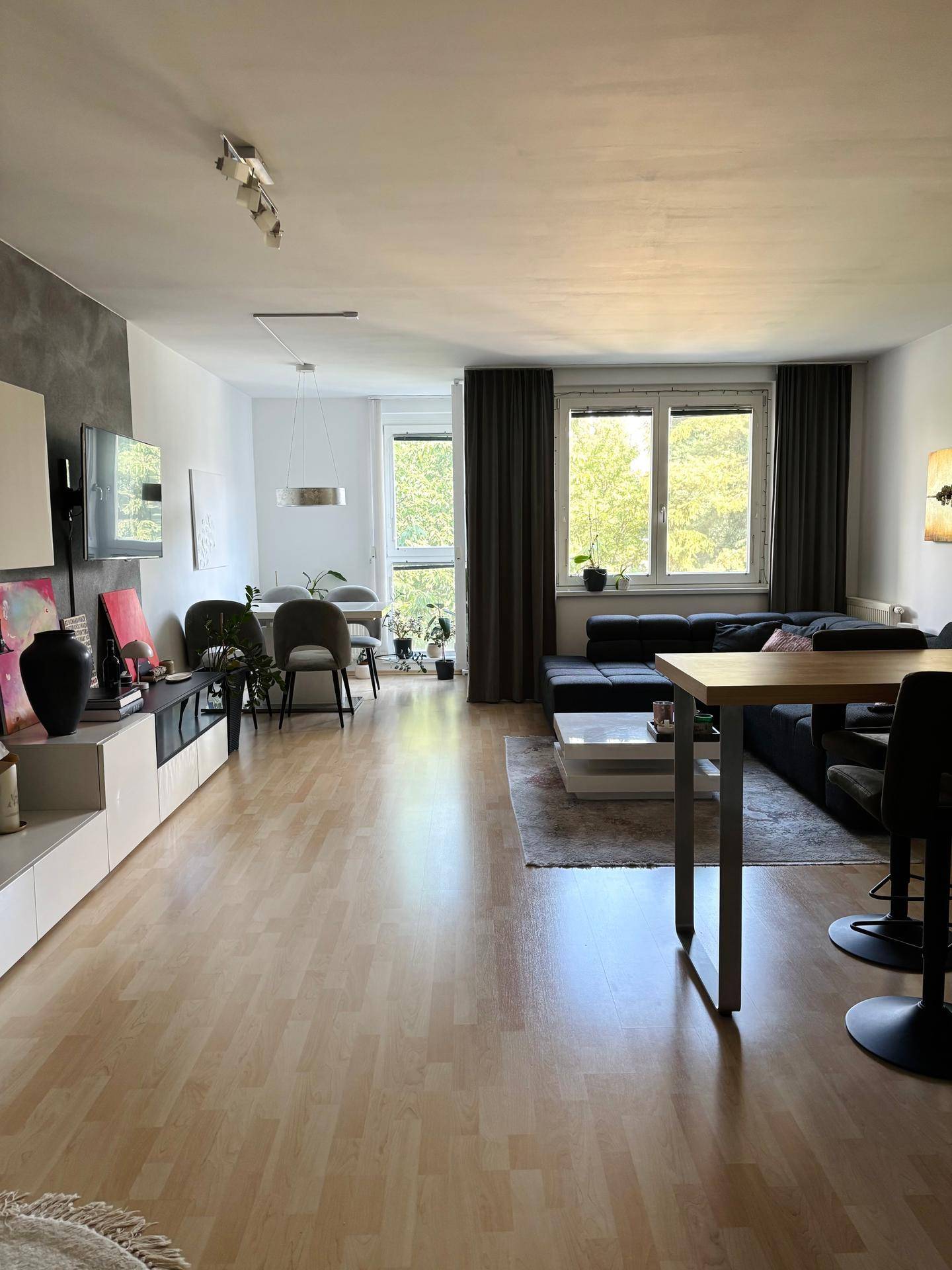 Heller und offener Wohn-Essbereich mit großen Fenstern und modernem Interieur.