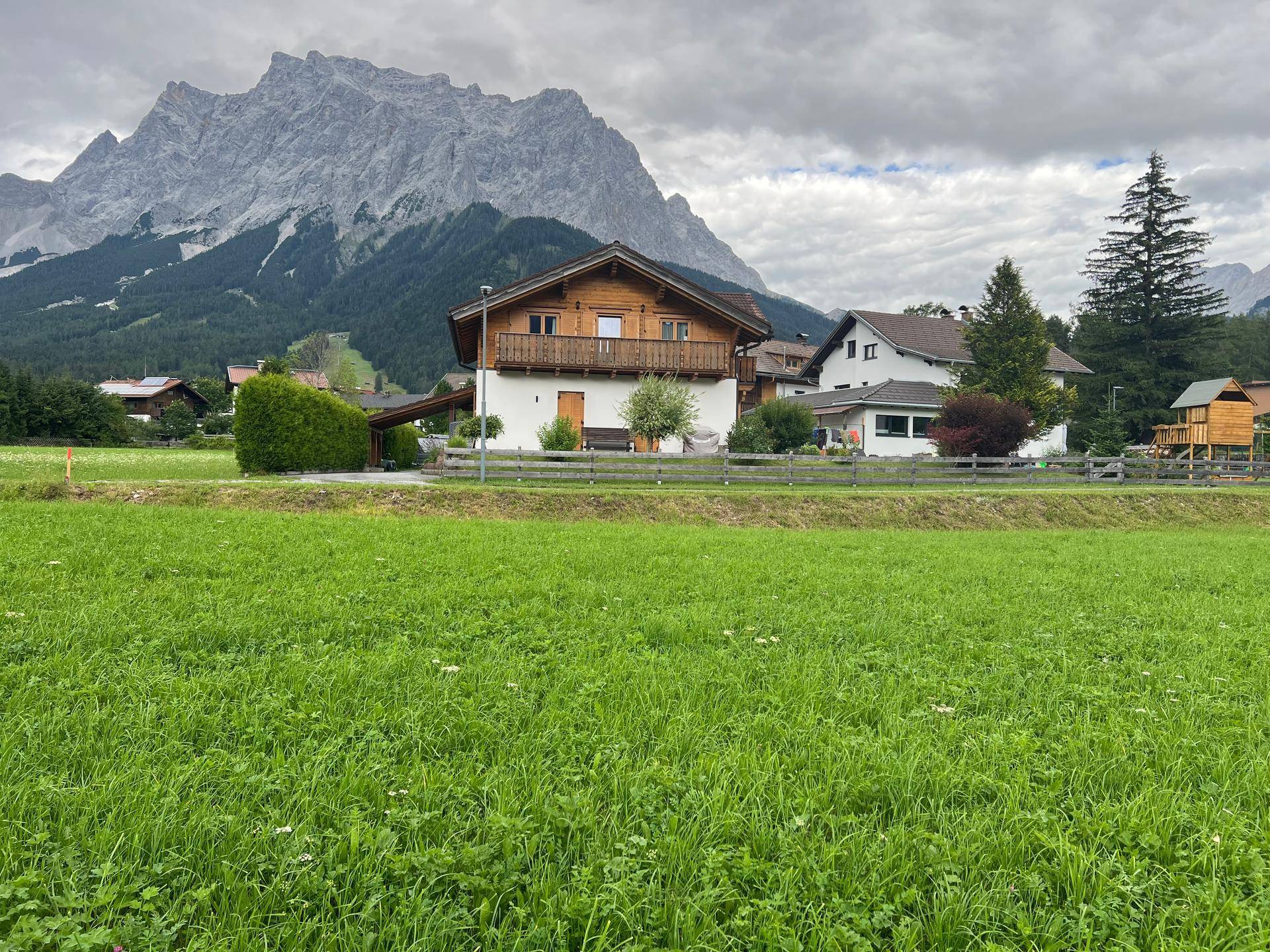 Traditionelles Haus mit Holzbalkon und weitem Blick auf die umliegende Berglandschaft.