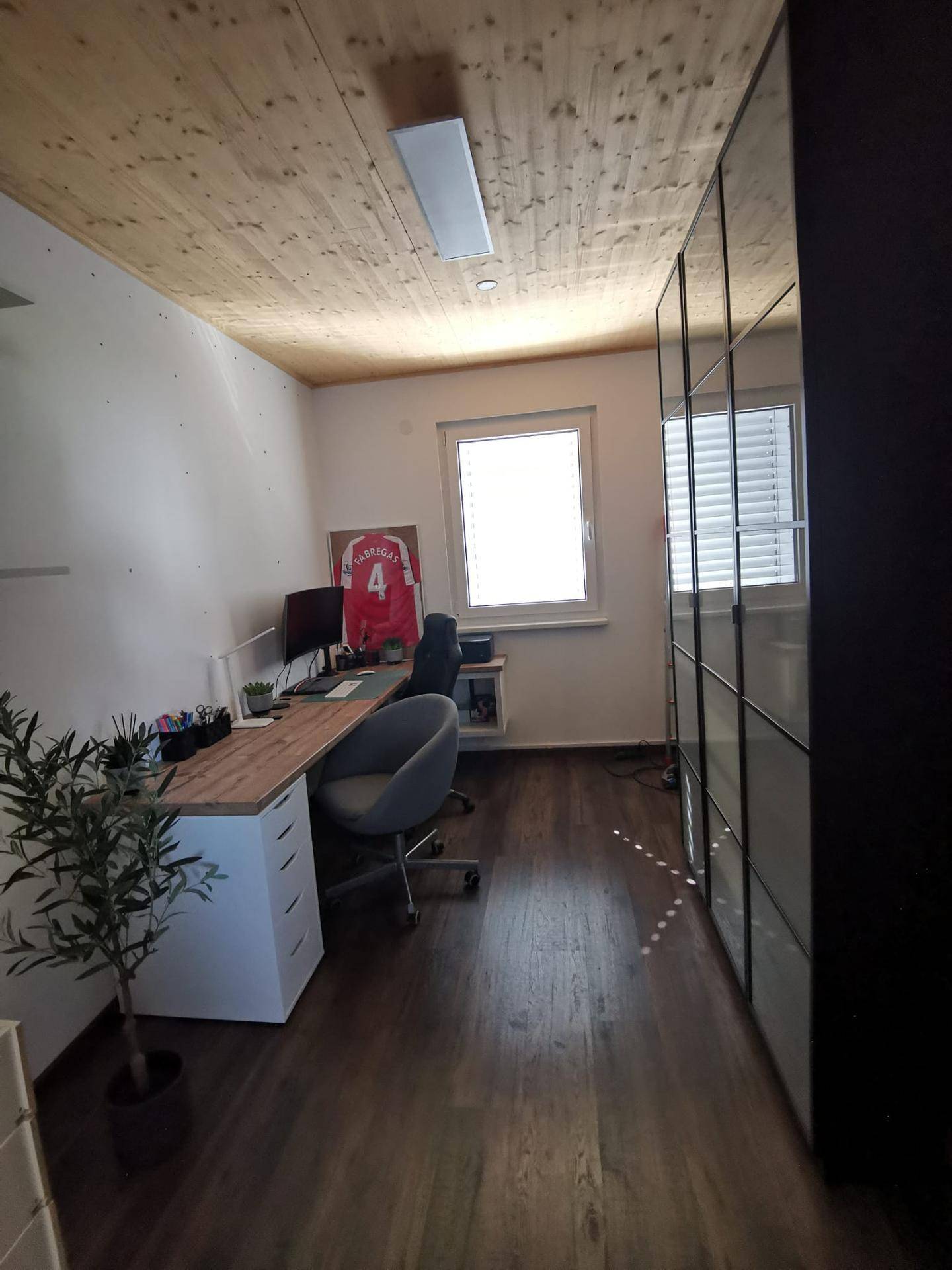 Modernes Arbeitszimmer mit großem Schreibtisch, Bürostuhl und Spiegelschränken.