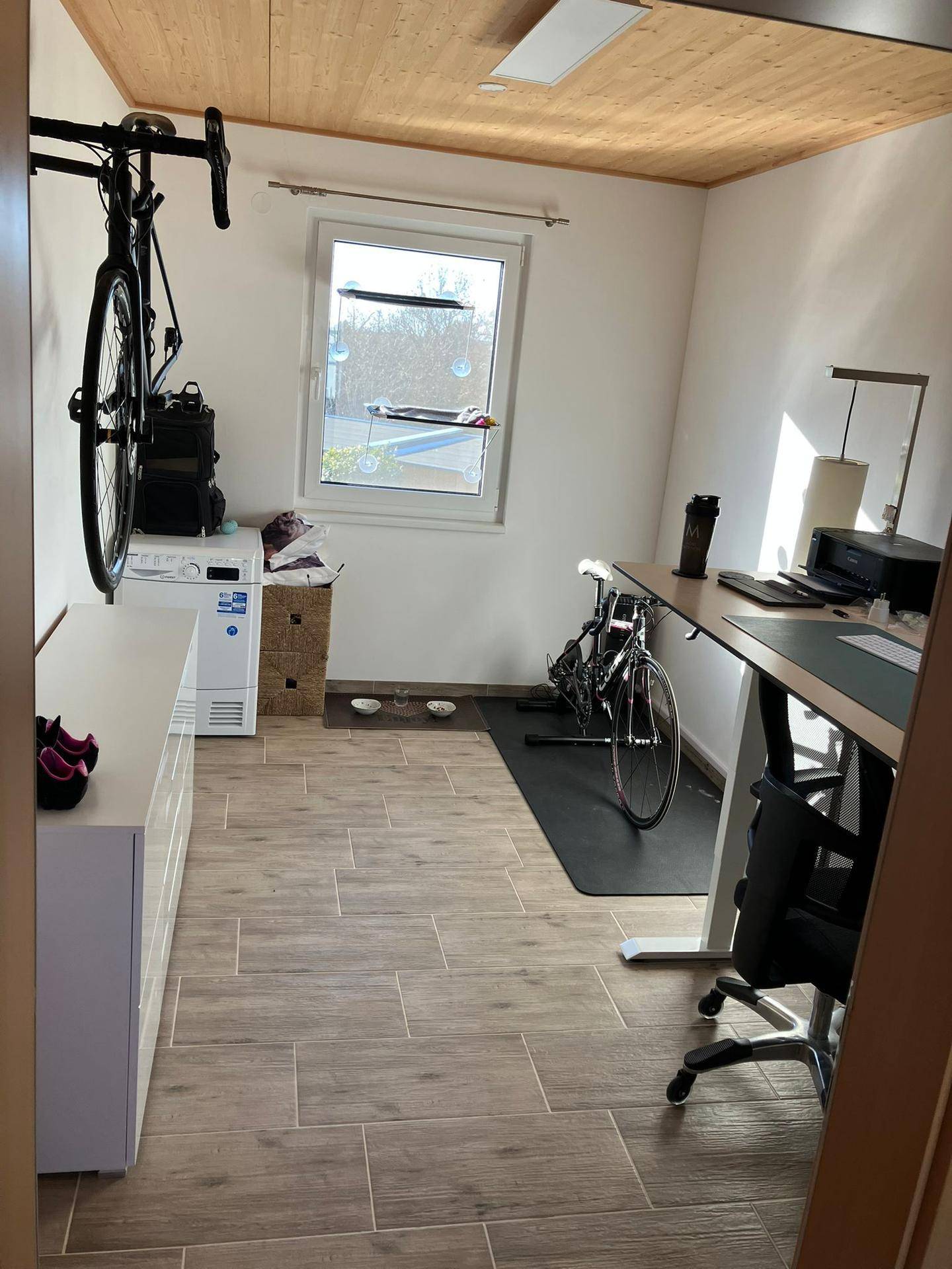 Arbeitszimmer mit Schreibtisch, Bürostuhl und einem Fahrrad an der Wand.