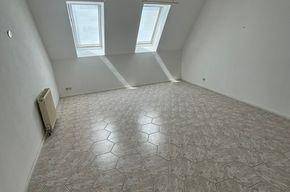 Helles Dachgeschosszimmer mit gemustertem Fliesenboden, Dachfenstern und Heizkörper.