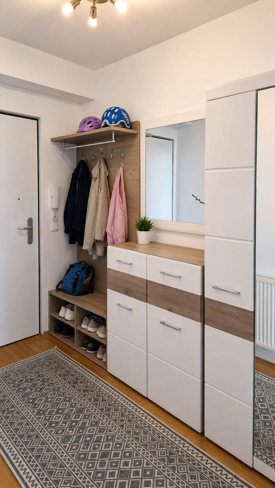Heller Eingangsbereich mit praktischen Garderobenschränken, Spiegel und Holzdetails.